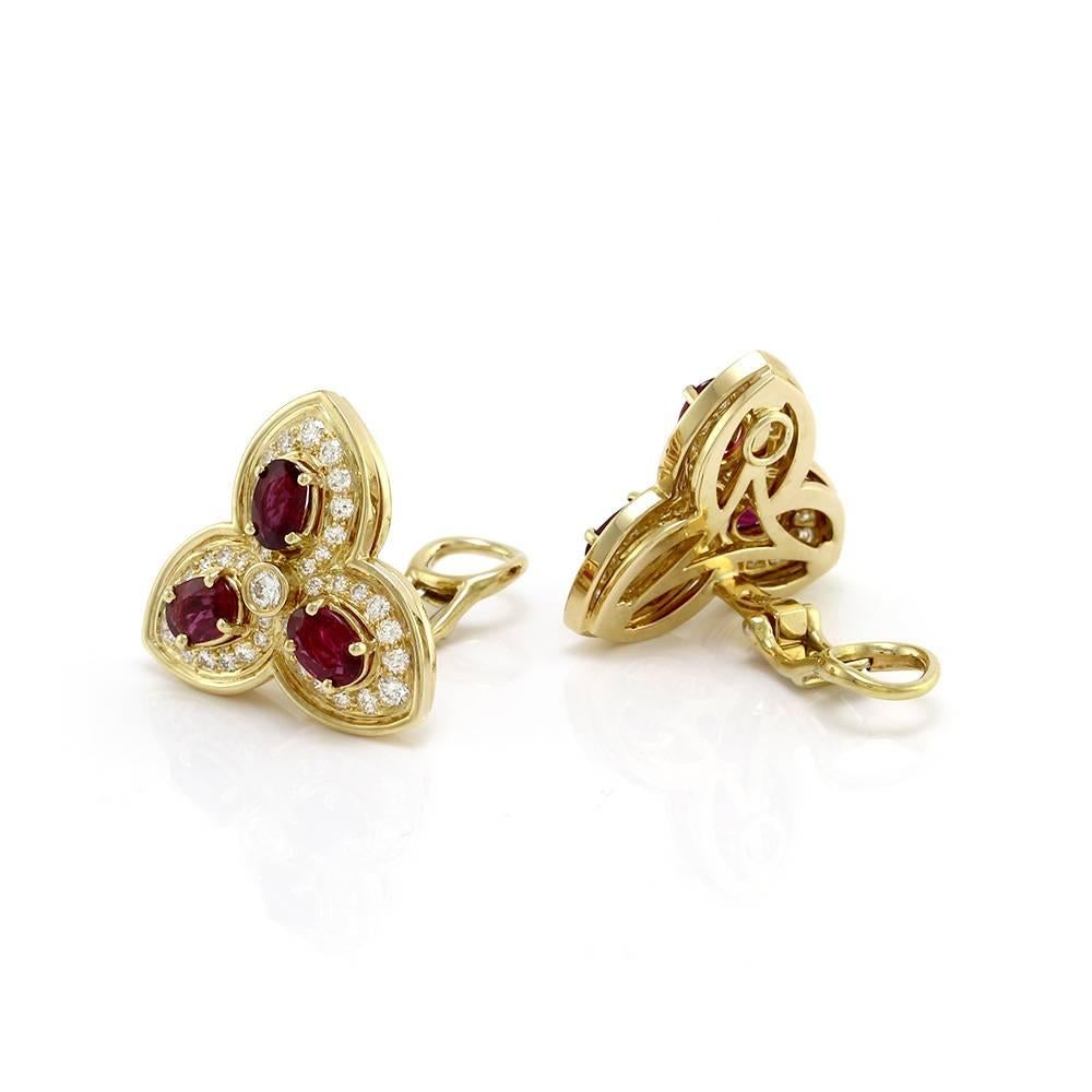 Hammerman Brothers ruby and pavé diamond trefoil clip-on earrings set in 18K yellow gold. There are six oval faceted rubies (4.80ctw) and eighty round brilliant cut diamonds (2.13ctw) with a color of E-F and a clarity of VS. The rubies are prong