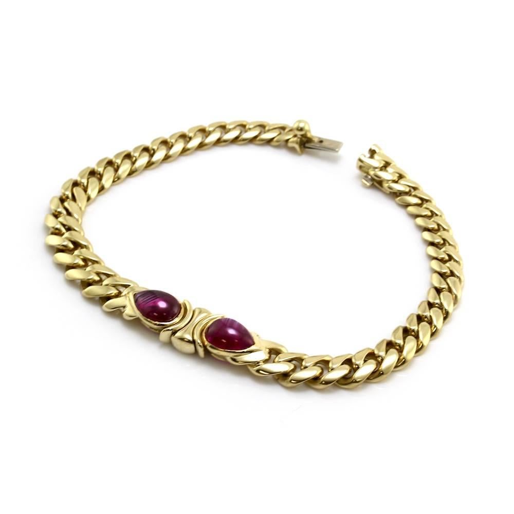 Bvlgari (Bulgari) ruby cabochons center curb link bracelet set in 18K yellow gold. There are two pear shaped ruby cabochons (4.88ctw) that are bezel set in high polish 18K yellow gold. The ruby links are 8.9mm wide, on a 5.0mm-6.0mm tapered curb