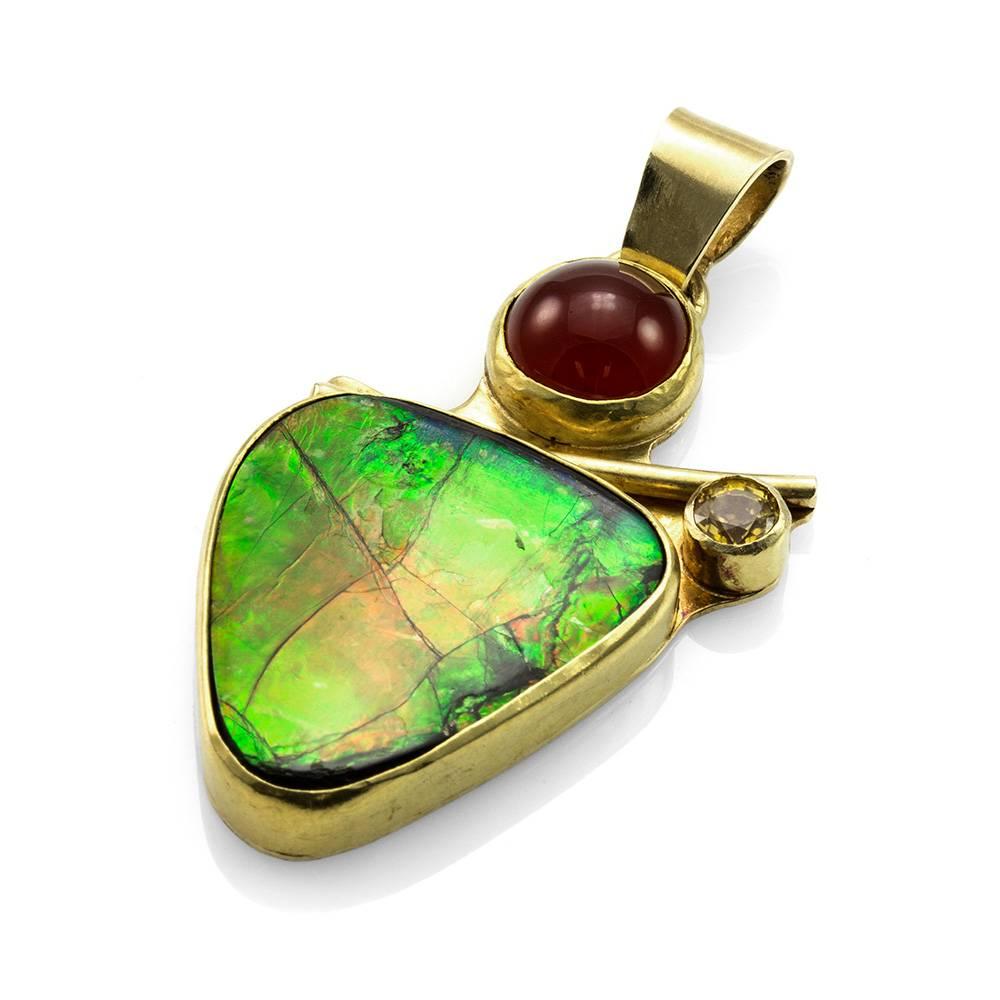 Vintage artisan Jan McClellan handmade ammolite, chrysoberyl, and carnelian pendant in 18K yellow gold. There are one triangle cut ammolite (24.0mm x 22.0mm), one round faceted chrysoberyl (0.50ct), and one round cabochon cut carnelian (10.0mm). The