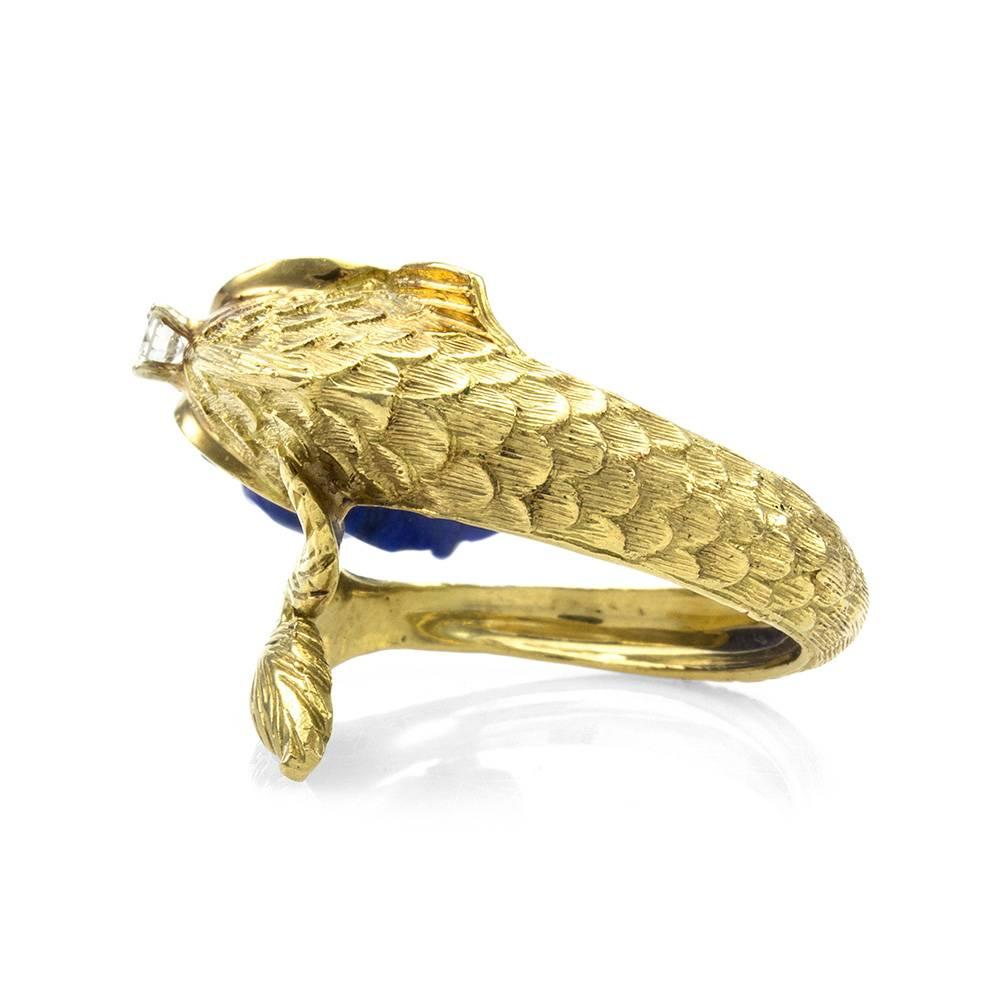 Vintage high detailed carved lapis lazuli fish ring in 18K yellow gold. There are one carved lapis lazuli and one round brilliant cut diamond (0.10ct). The diamond has a color of G and a clarity of SI2. The overall size of this ring is (Head/