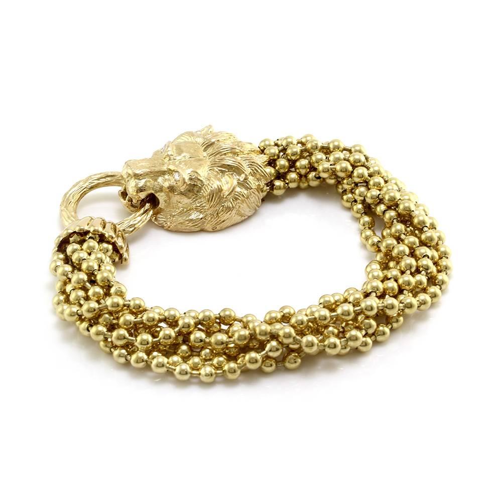 Signed designer Van Cleef & Arpels seven strand bracelet with lion’s head closure in 18K yellow gold. There are two round brilliant cut diamonds with a color of E and a clarity of VS1. The lion’s head closure and ring measure 30.9mm x 61.3mm when