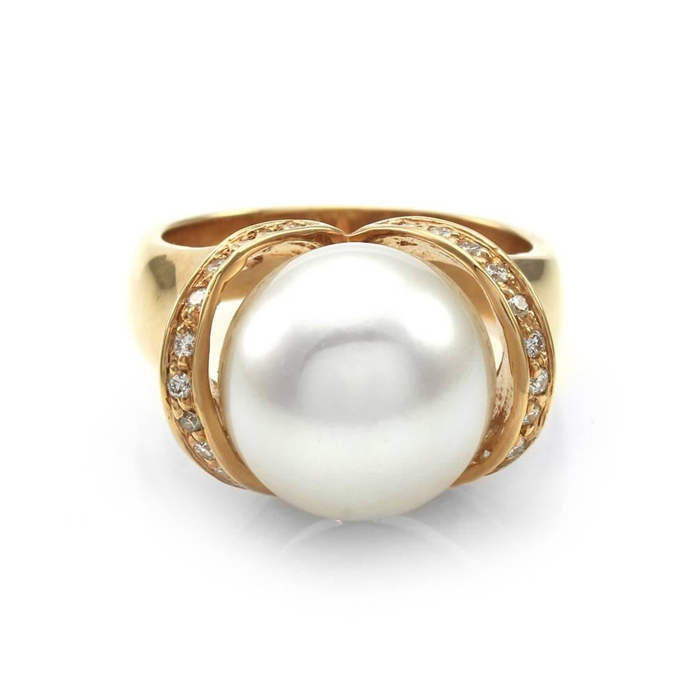 South Sea pearl ring with diamond accents in high polished 18K rose gold. There are one round, cream white South Sea pearl (12.5mm) and twenty-six round brilliant cut diamonds (0.52ctw). The bead set diamonds have a color of E-F and a clarity of