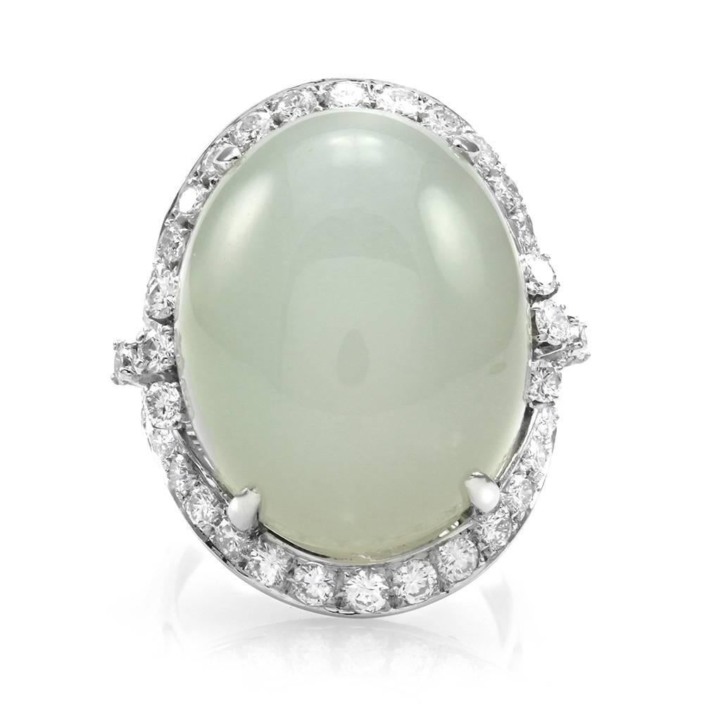 Moonstone cabochon and pavé diamond halo ring set in platinum. There are one oval moonstone cabochon (31.11ct) and forty-two round brilliant cut diamonds (2.33ctw) with a color of G-H and a clarity of VS. The moonstone is prong set, and the