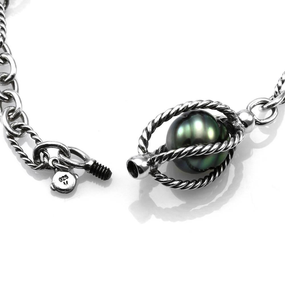 David Yurman Bijoux caged tahitian pearl necklace set in sterling silver. There are six high peacock luster tahitian pearls (1.1.0mm-11.5mm) in twisted cable cages (appx. 15.0mm), on a figaro chain. This necklace has a fancy hidden screw clasp. The