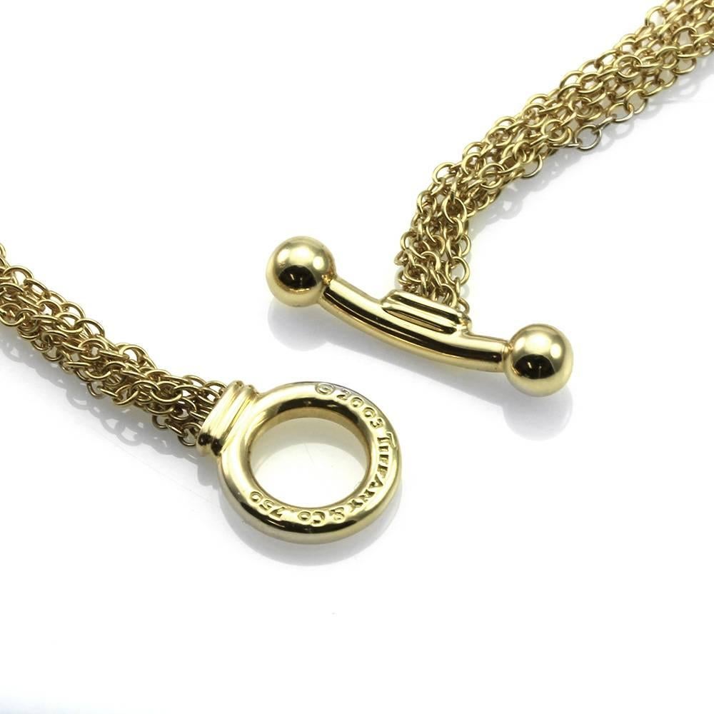Tiffany & Co. South Sea drop pearl six strand chain necklace set in 18K gold. There is one white South Sea drop pearl (11.3mm x 12.0mm) with a high polish 18K gold cap. The pendant comes on six strands of 1.6mm rolo link chain, finished with high