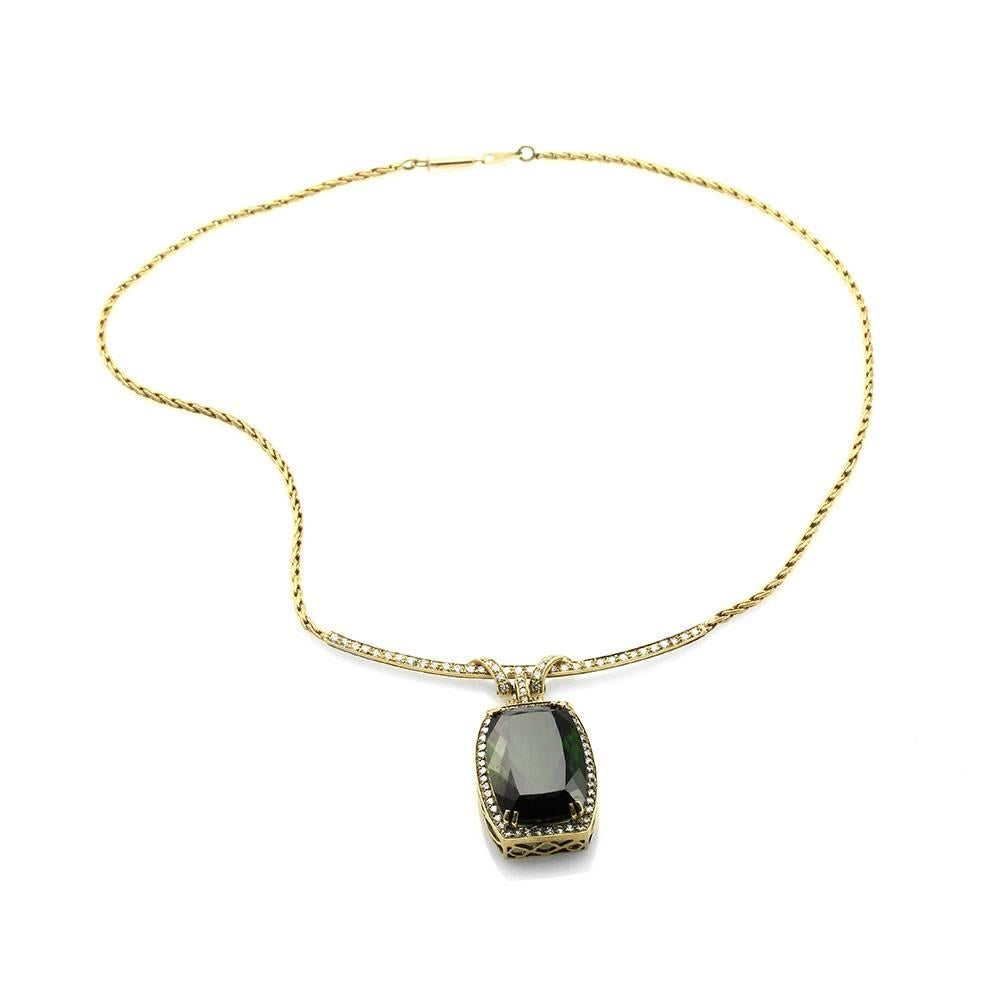 Green tourmaline and pavé diamond station necklace set in 18K yellow gold. There are one elongated cushion tourmaline (34.82ct) and eighty-seven round brilliant cut diamonds (2.08ctw) with a color of G-I and a clarity of VS-SI. The tourmaline is