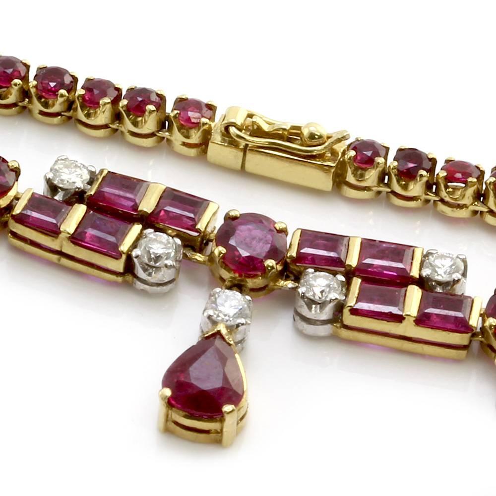 Ruby necklace with diamond accents set in 18K yellow gold. There are one hundred forty-two round, square, and pear faceted rubies total (21.35ctw) and twenty-five round brilliant cut diamonds (1.10ctw) with a color of G-H and a clarity of VS-SI. The