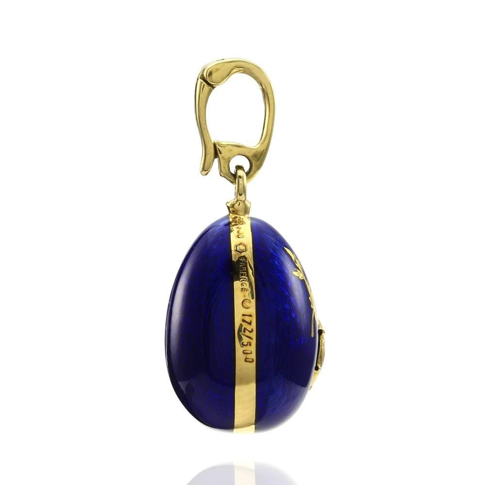 Fabergé blue enamel egg with ladybug pendant enhancer set in 18K yellow gold. There is a red, black, and white enamel ladybug raised embellishment and an accent of leaves of gold in the blue enamel. The bail measures 4.6mm. This pendant measures