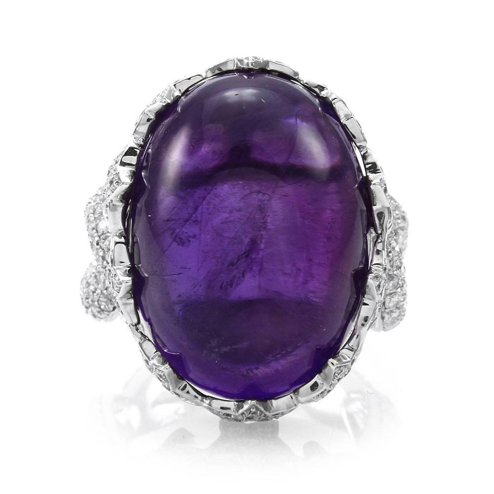 Amethyst cabochon and pavé diamond star bezel ring set in 18K white gold. There are one oval amethyst cabochon (27.58ct) and two hundred fifty round brilliant cut diamonds (1.96ctw) with a color of G-H and a clarity of VS. The amethyst is custom