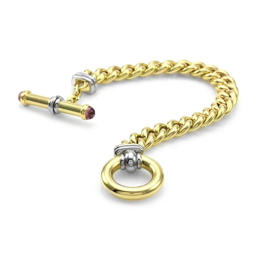 Signoretti curb link bracelet with tourmaline accents in 18K yellow gold. There are two round tourmaline cabochons (5.5mm) that are bezel set on the toggle clasp. This bracelet is 9.8mmm wide and 7.75 inches long. The total weight of this bracelet
