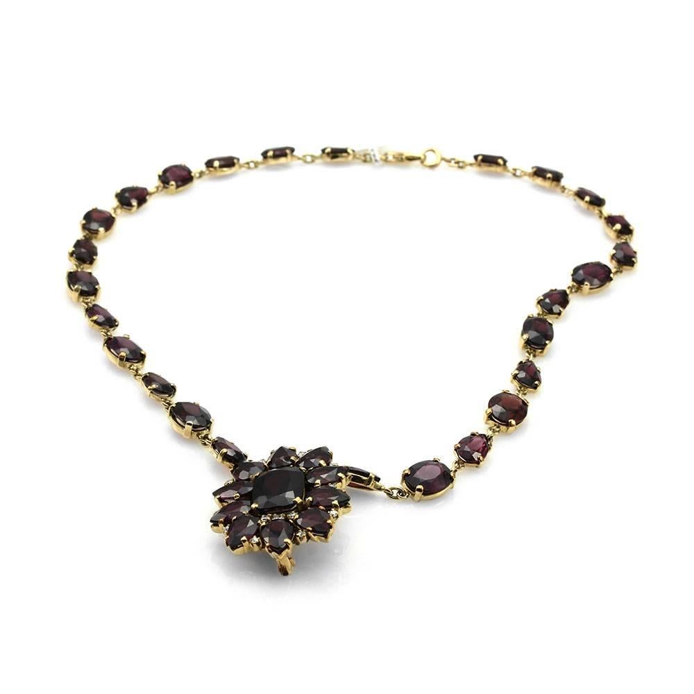 Antique garnet and diamond necklace convertible brooch set in 10K yellow gold. There are thirty-eight pear and oval faceted garnets total (51.81ctw) and sixteen European cut diamonds (0.50ctw) with a color of G-H and a clarity of SI. All gemstones