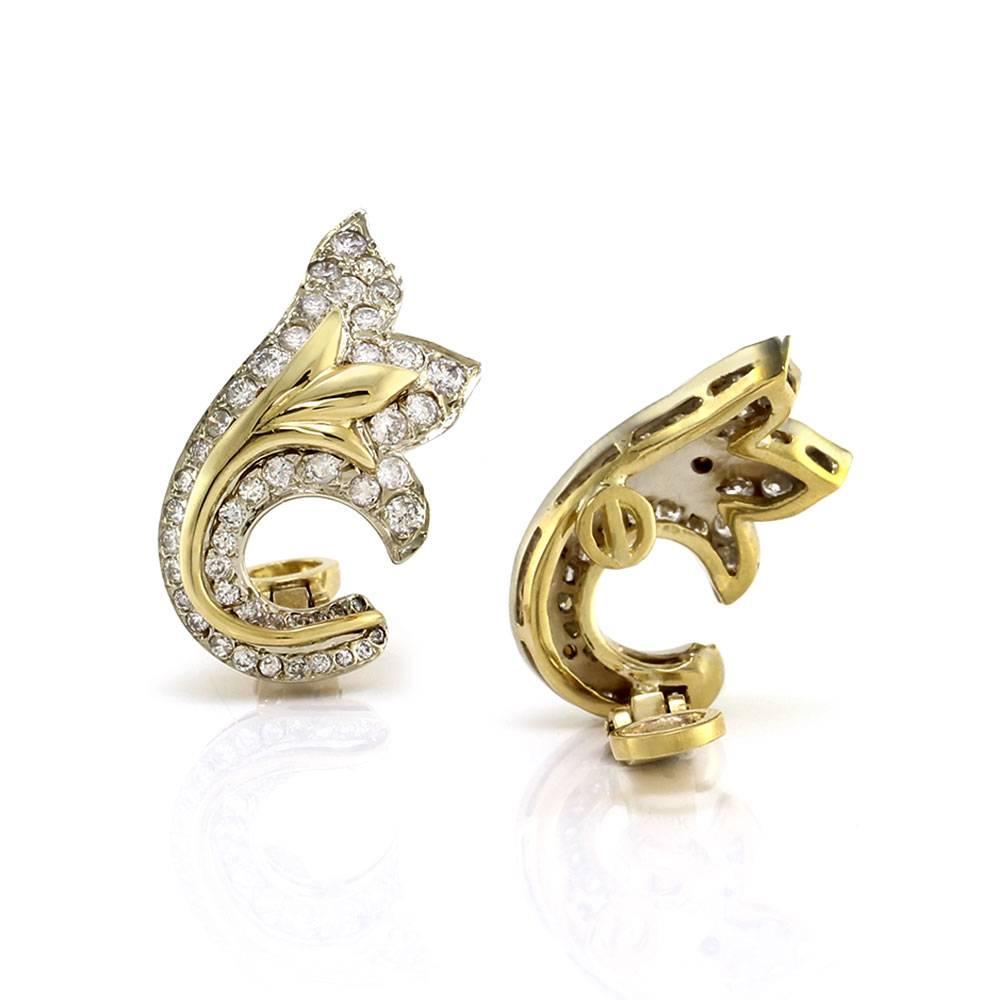 Pavé diamond leaf fashioned climber clip-on earrings in 18K yellow gold. There are ninety-two round brilliant cut diamonds (2.08ctw) with a color of G-I and a clarity of SI. The diamonds are bead set. Each earring measures 27.9mm x 15.3mm, with a