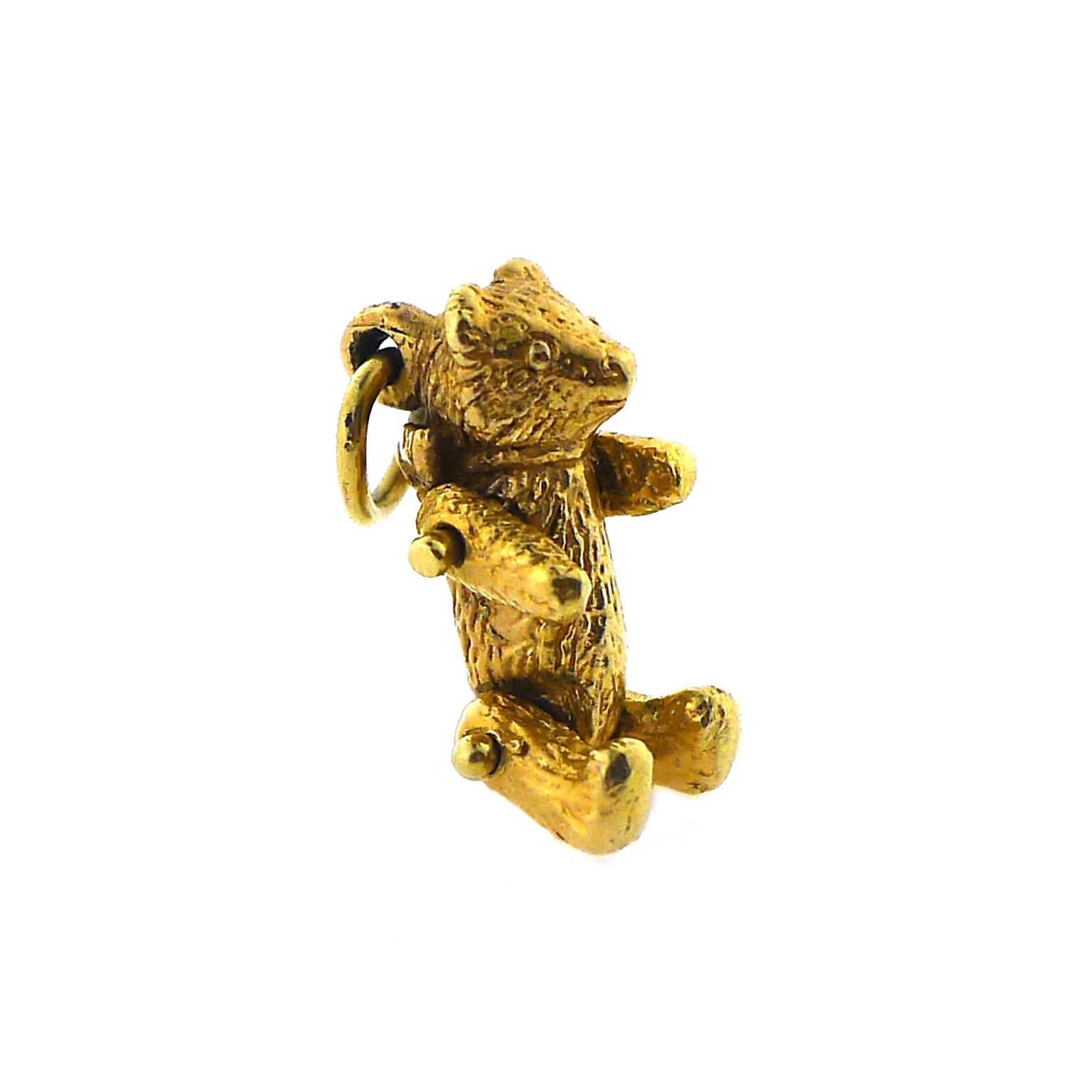 Adorable 14 karat yellow gold teddy bear with moving arms and legs, weighing 2.16 pennyweight. Attached to rear double jump rings. 1/2 inch long from head to foot.