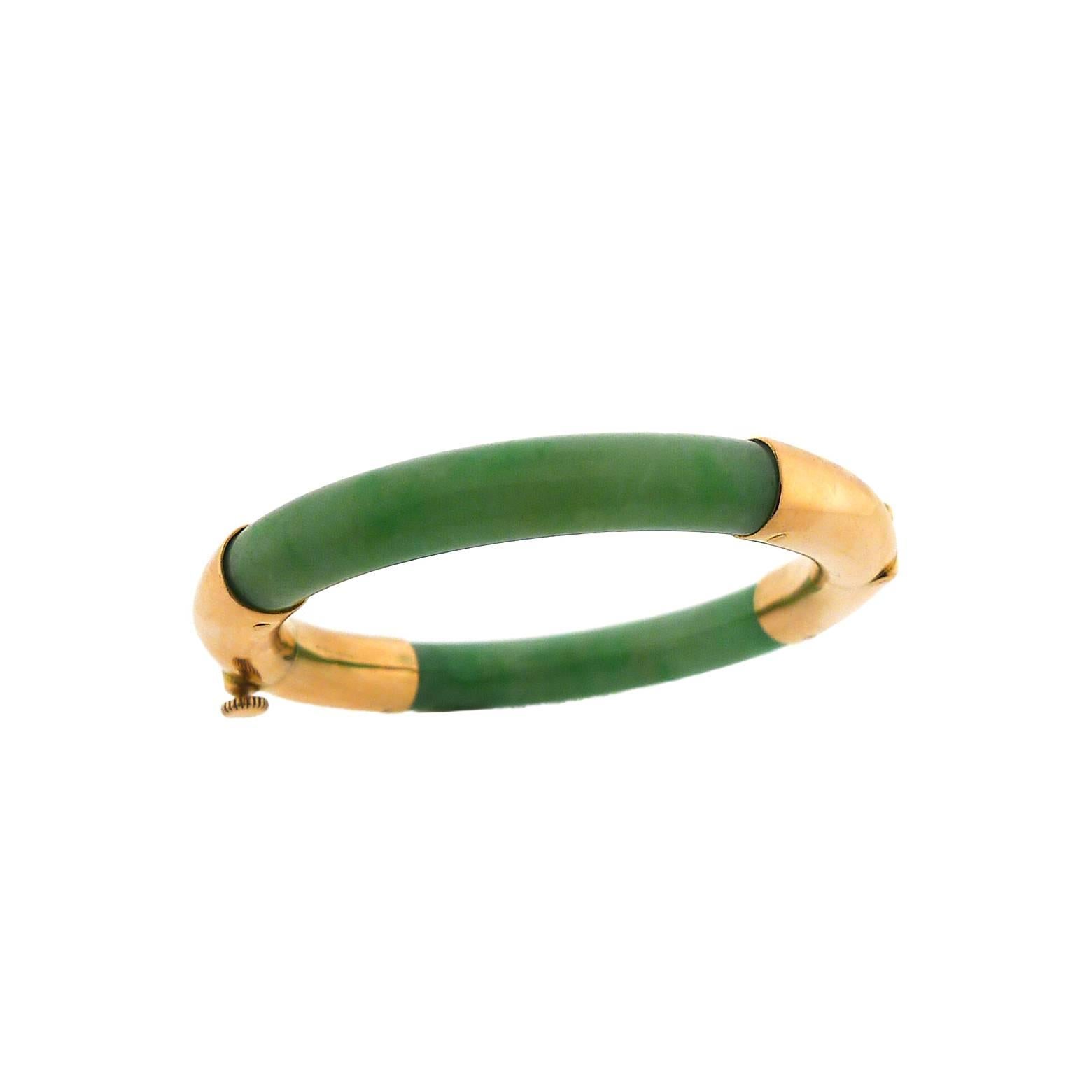 Circular bangle has two rose gold sections, one with a hinge and the other with screw clasp. Jadeite measures 7.85 millimeter wide and the inside diameter of the closed bangle is 2". Probably made in Asia in the 1930's. 14 karat rose gold.