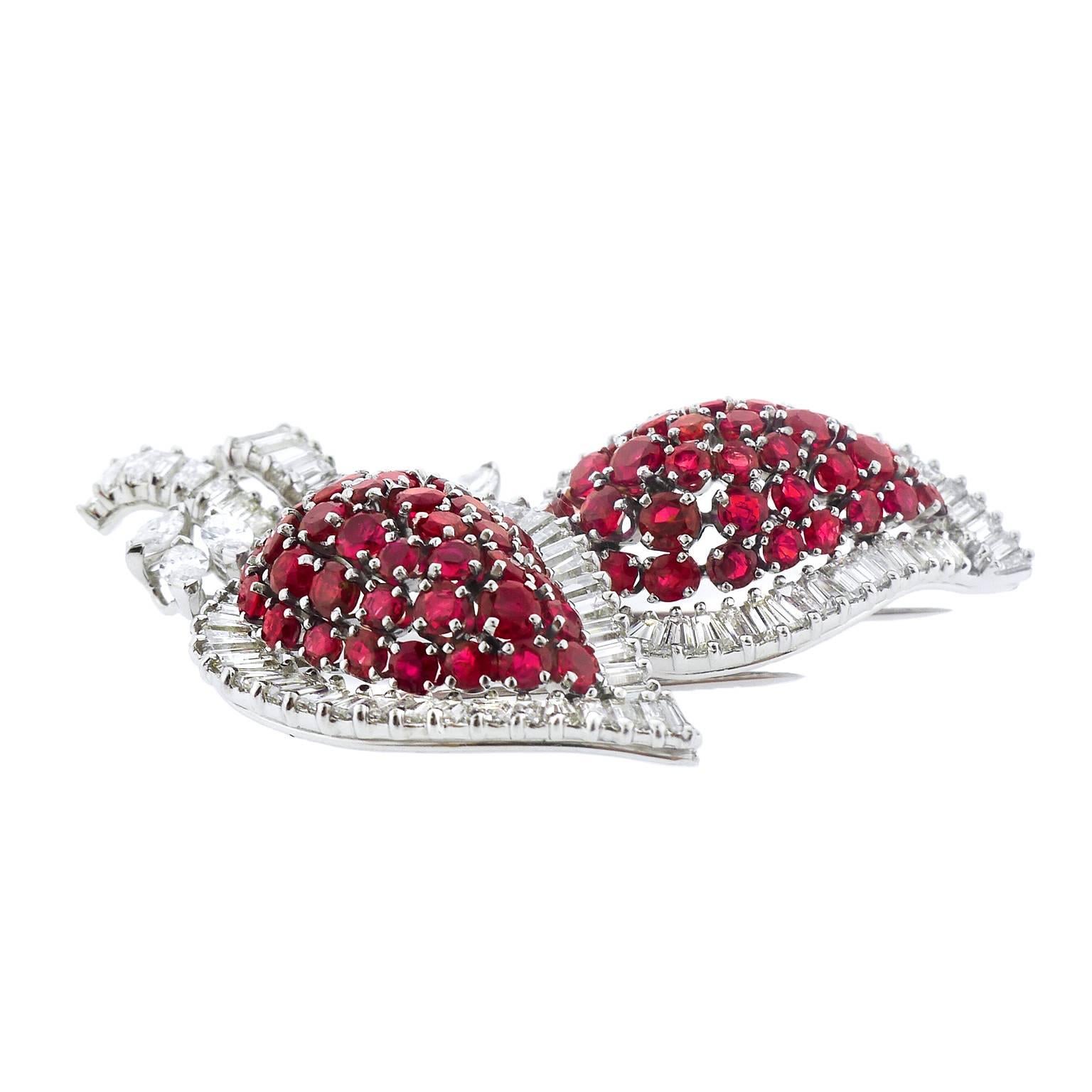 A spectacular ruby and diamond brooch, created circa 1940s, featuring 82 round, faceted rubies totaling approximately 6 carats, 6 marquise cut diamonds totaling approximately 1.20 carats and 91 tapered baguette diamonds totaling approximately 5.75