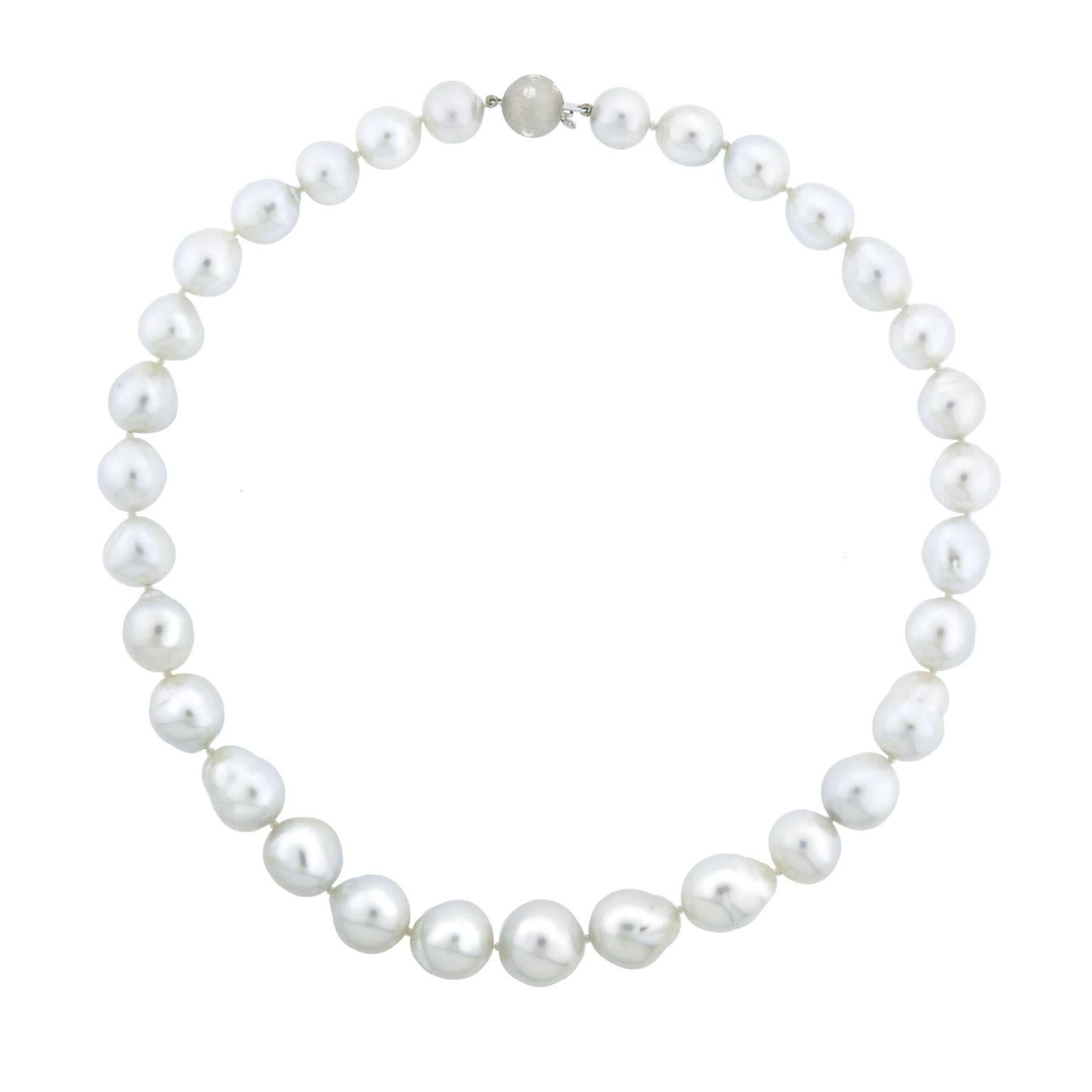 31 semi-baroque pearls range in size from 9.9 to 13.2 millimeter. The luster is extremely high, the surface is mostly free of blemishes and the color is a silver white with accents of pale pink and green. The clasp is 14 karat white gold, has a