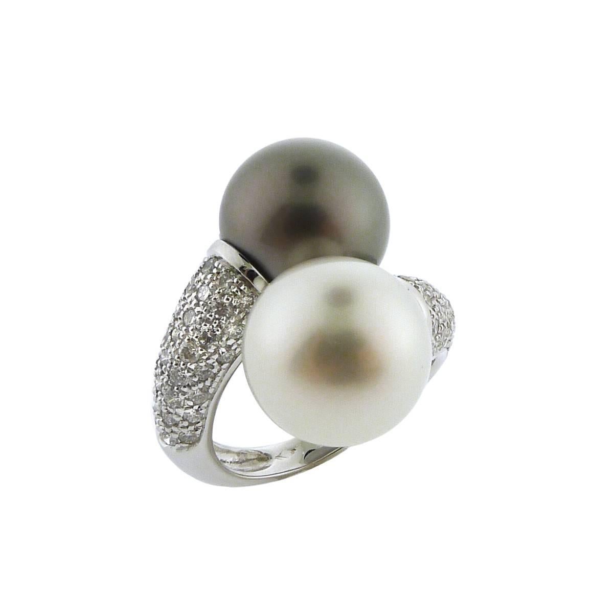 Two large, fully round pearls measure 12.7 mm each, have excellent luster and are blemish free. 1.20 carats of G color, VS-SI clarity diamonds are pavé set in 18K white gold. The ring measures 1 inch from top to bottom, 0.75 inches across, and sits
