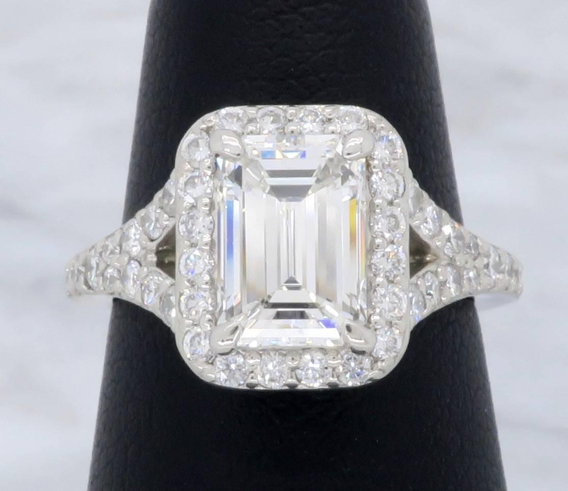 Elegant GIA Certified Emerald Cut Halo Diamond Engagement Ring. The center diamond is a 1.27CT Emerald cut and has G color and VS2 clarity, the GIA certification number is 2111457700. The gorgeous split shank Platinum ring is adorned with 44