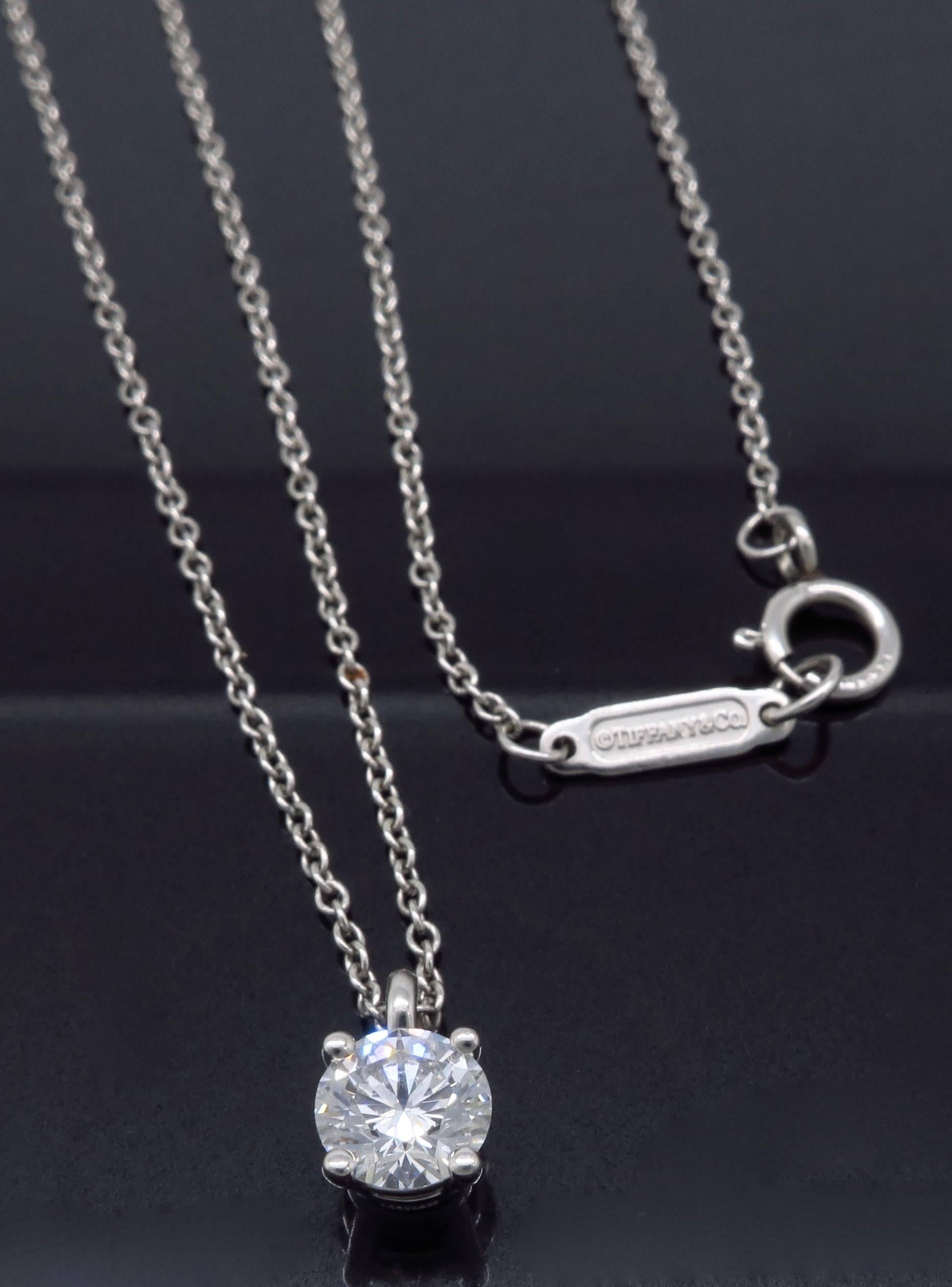 Platinum Tiffany & Co. Diamond Solitaire Pendant features a .45CT Round Brilliant Cut Diamond with F color, VVS1 clarity. The platinum necklace is 16” in length and weighs 2.8 grams.