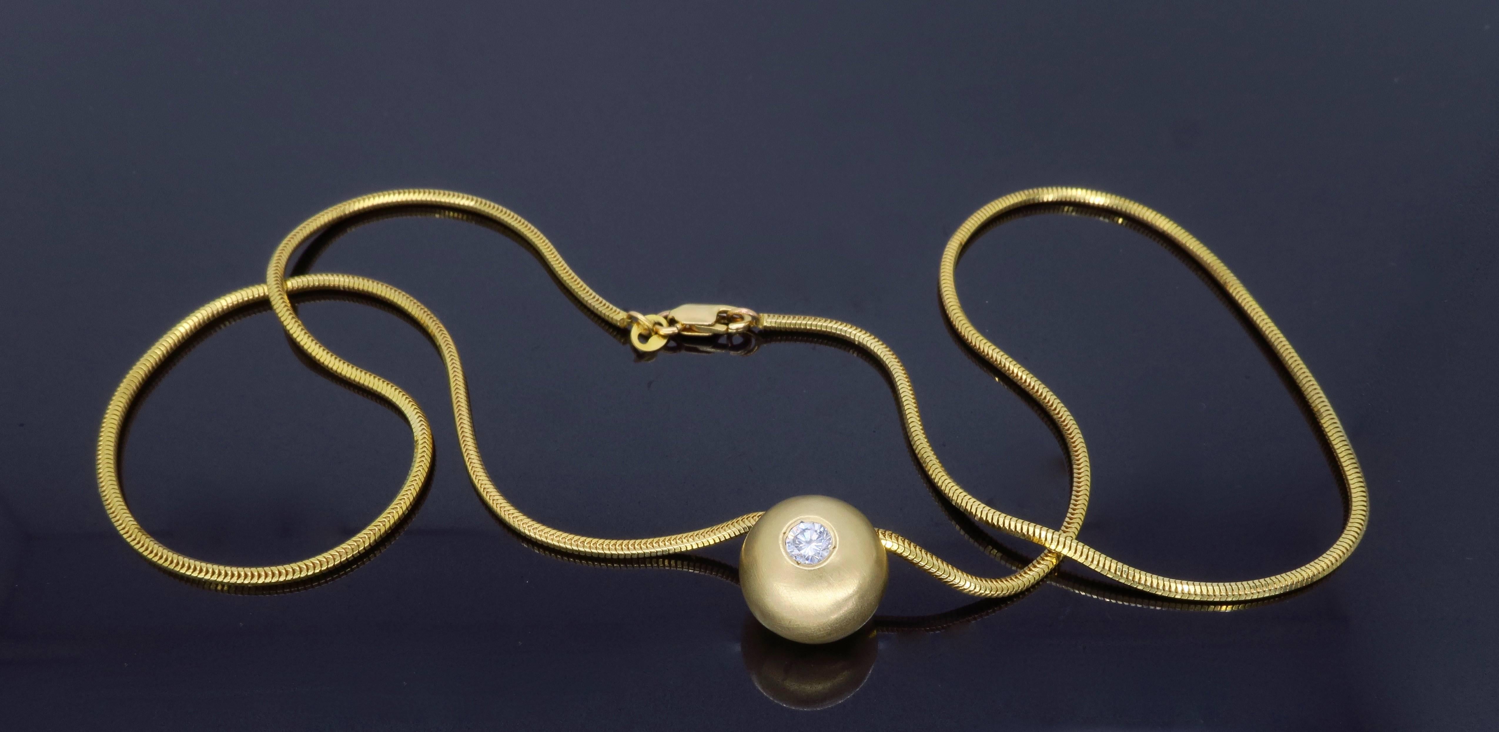 Unique matte finished ball pendant features an approximate .25CT Round Brilliant Cut Diamond set in a 14K yellow gold. The featured diamond displays G-H color and VS2 clarity. The 14K yellow gold necklace is 18” in length and weighs 12.1 grams.
