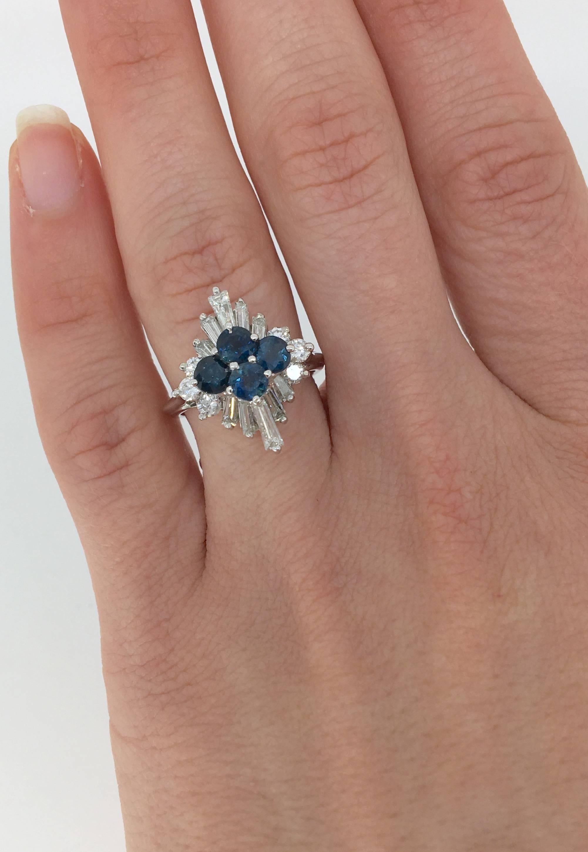 18k white gold diamond and sapphire ring featuring 10 (ten) Baguette cut diamonds, 6 (six) Round Brilliant cut diamonds surrounding 4 (four) Round blue sapphires. The total diamond weight is approximately 1.04ctw, and the 18k white gold ring is
