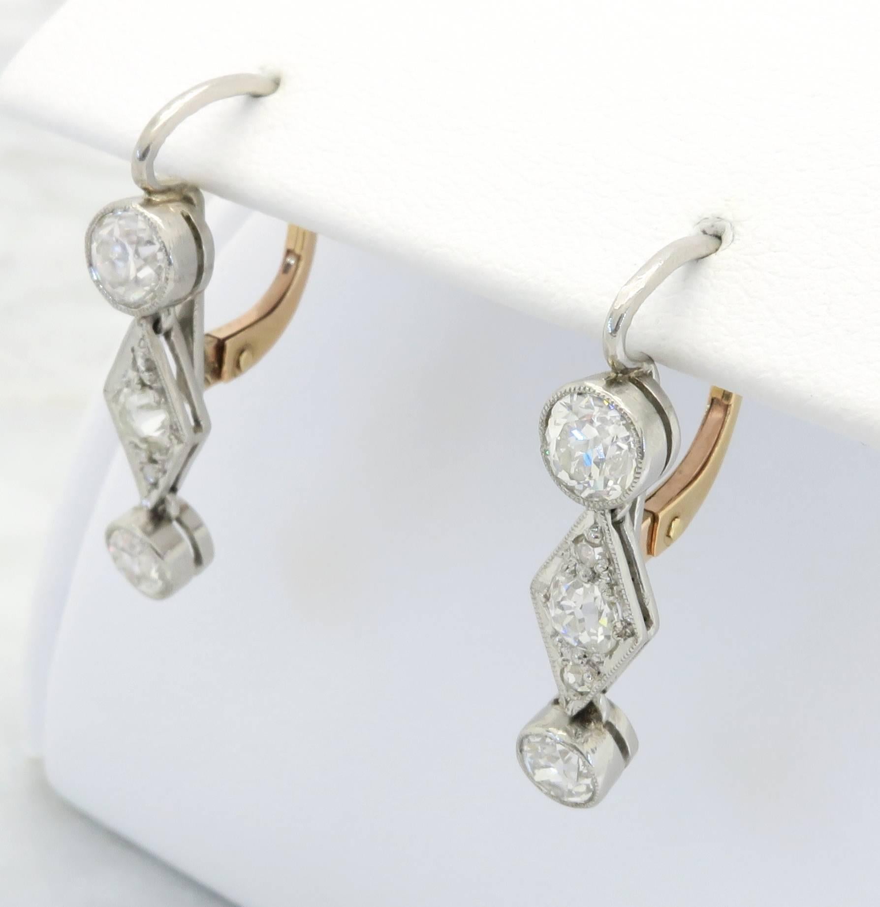 1920's diamond earrings featuring four (4) Old European Cut Diamonds, two (2) Old Mine Cut Diamonds and four (4) Rose Cut Diamonds. The diamonds have F-H color and VS-SI clarity. The total diamond weight is approximately 1.06CTW. The earrings are