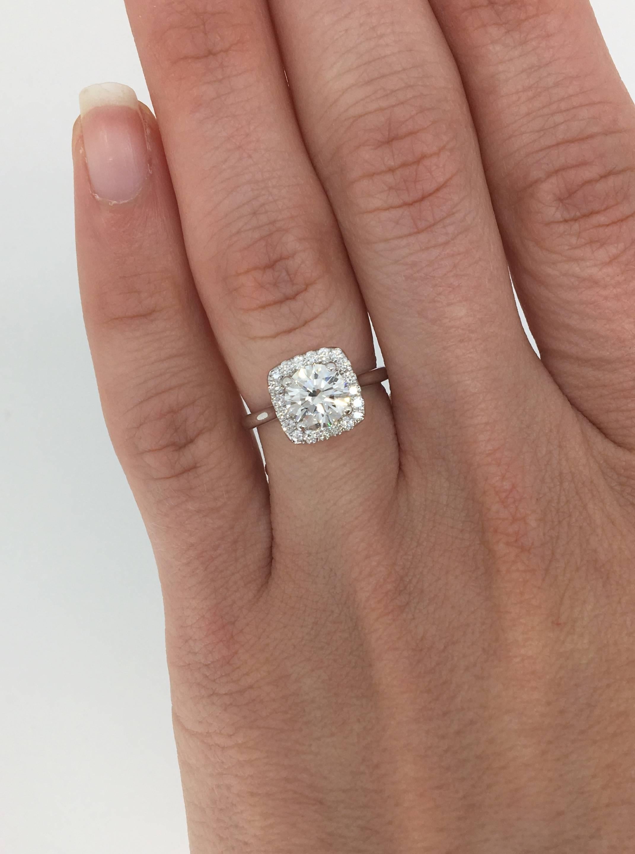 Elegant halo style engagement ring features a GIA Certified 1.07CT Round Brilliant Cut Diamond in the center with J color, SI1 clarity according to GIA. There are 20 additional Round Brilliant Cut Diamonds set in a halo surrounding the featured