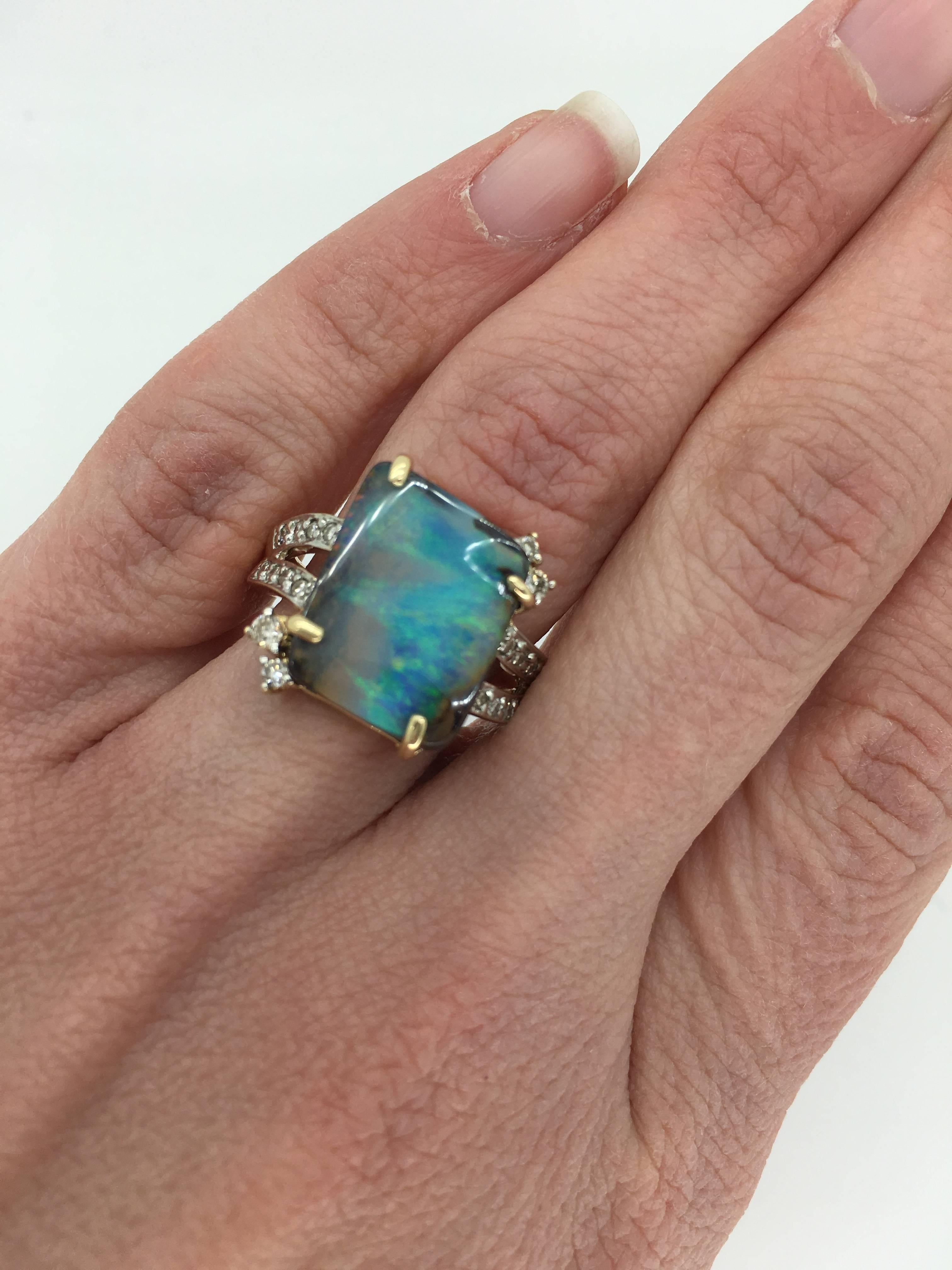 Custom made Opal ring features an approximately 14.25x11.45mm Rectangular Cut Opal accented by approximately .25ctw of diamonds. The 14K two-tone gold ring is currently a size 7 and weighs 5.6 grams.
