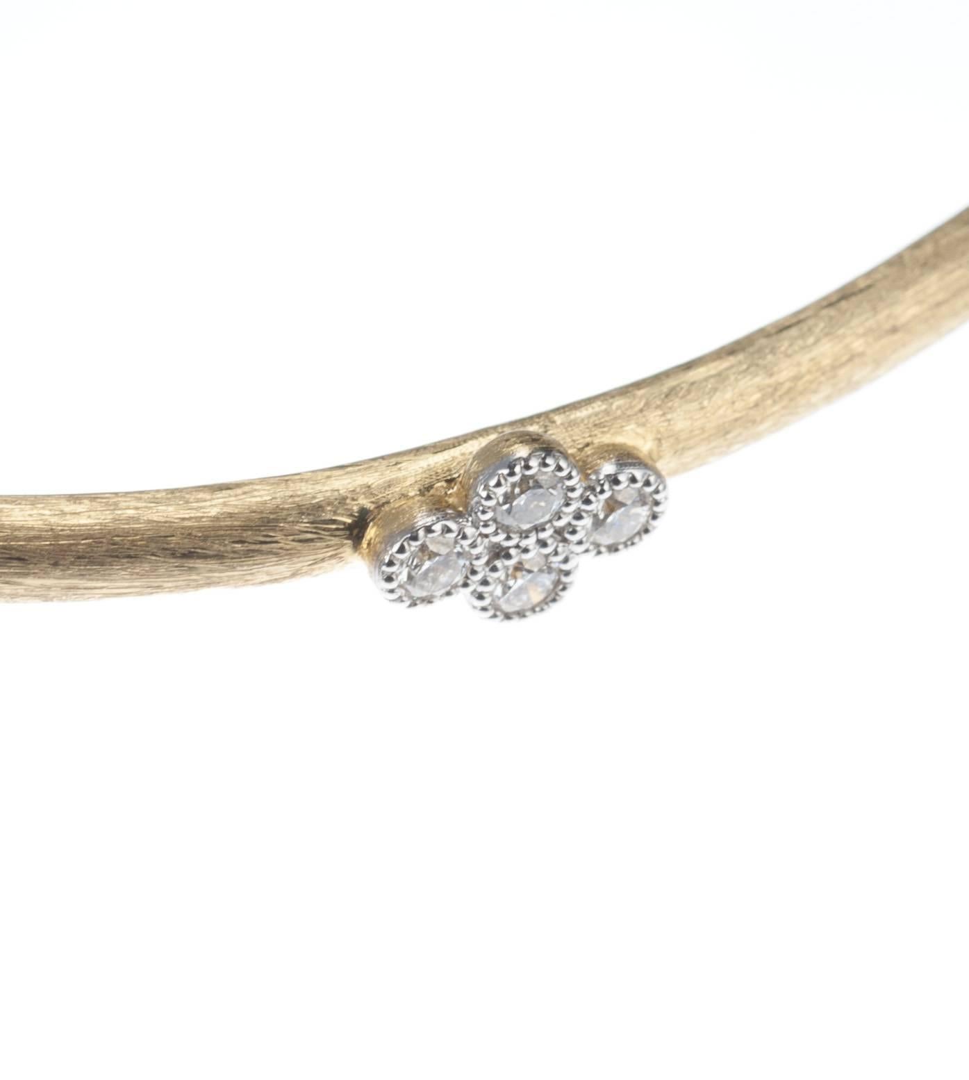 Part of the Provence collection from designer Jude Frances, a simple 18-karat yellow gold bangle bracelet applied with the designer’s signature Florentine-like finish and adorned with an 18-karat white gold quad of four diamonds, .12ctw. of G color