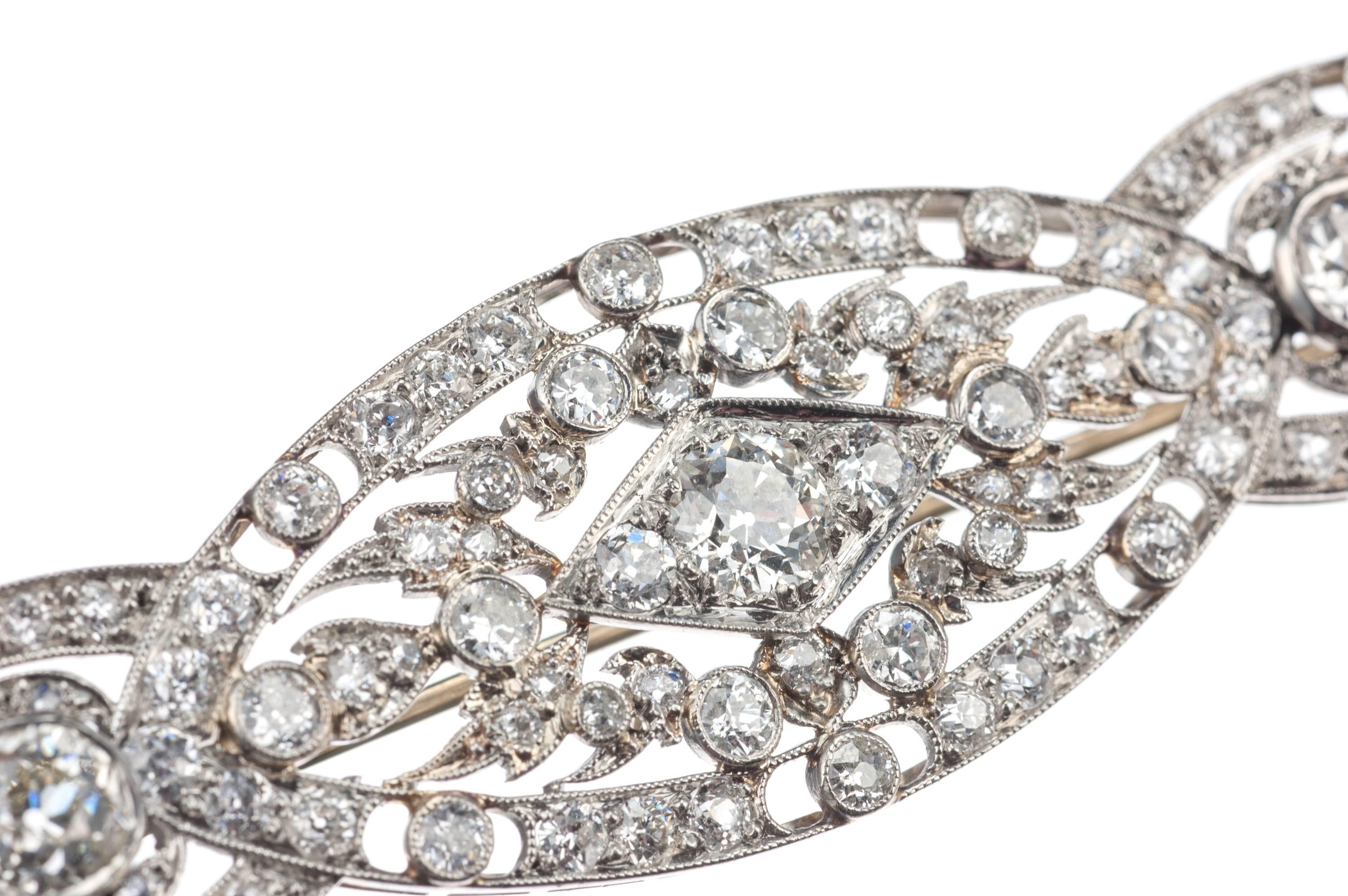 A classic art deco diamond brooch fashioned in platinum. Three old mine cut diamonds, approx. 1.63ctw of H-I color and VS clarity, feature as prominent centerpieces accented by 90 European and Old Mine cut diamonds, approx. 2.30ctw. of H-I color and
