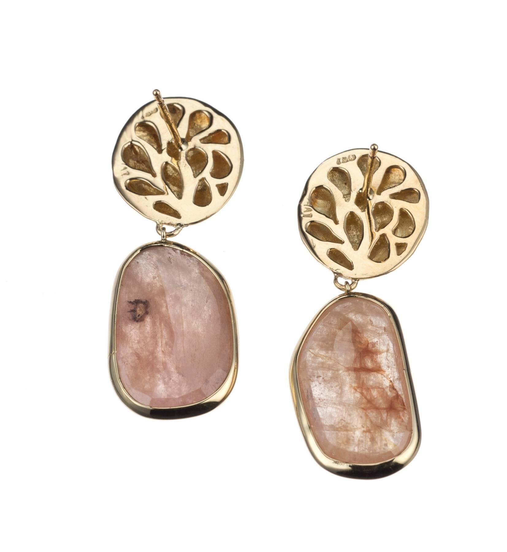 Faceted slices of pink sapphire, 40.00ctw., are suspended from textured buttons of 18-karat yellow gold in this pair of earrings by Israeli designer Yvel. Secured with posts and backs. Earrings measure approx. 1.5” in length.