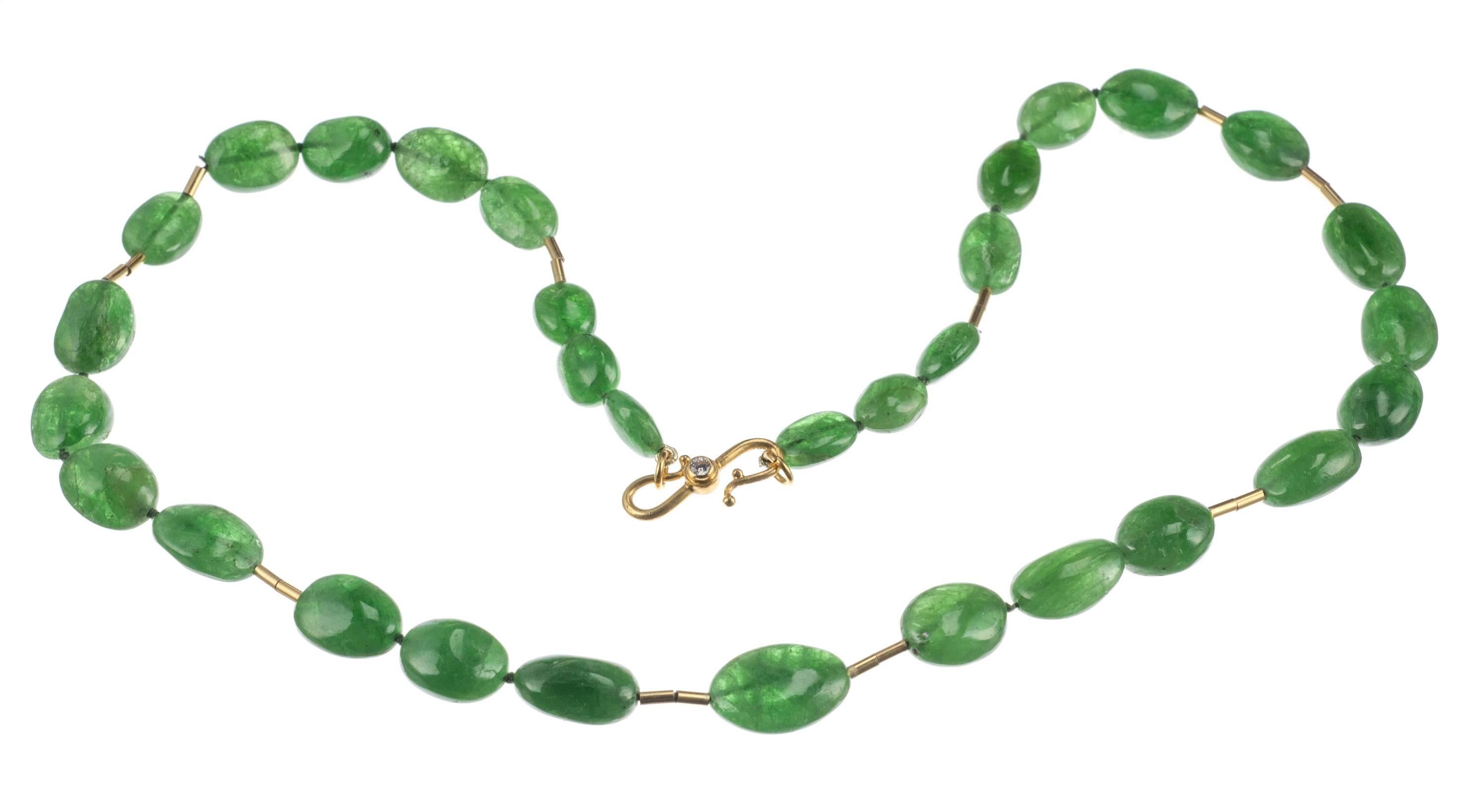 Smooth nuggets of brilliant green tsavorite are strung with 18-karat yellow gold tube beads in this necklace from Elleard Heffern Fine Jewelers. Secured with an “S”-hook clasp set with a single brilliant-cut round diamond, .07ct. Measures approx.