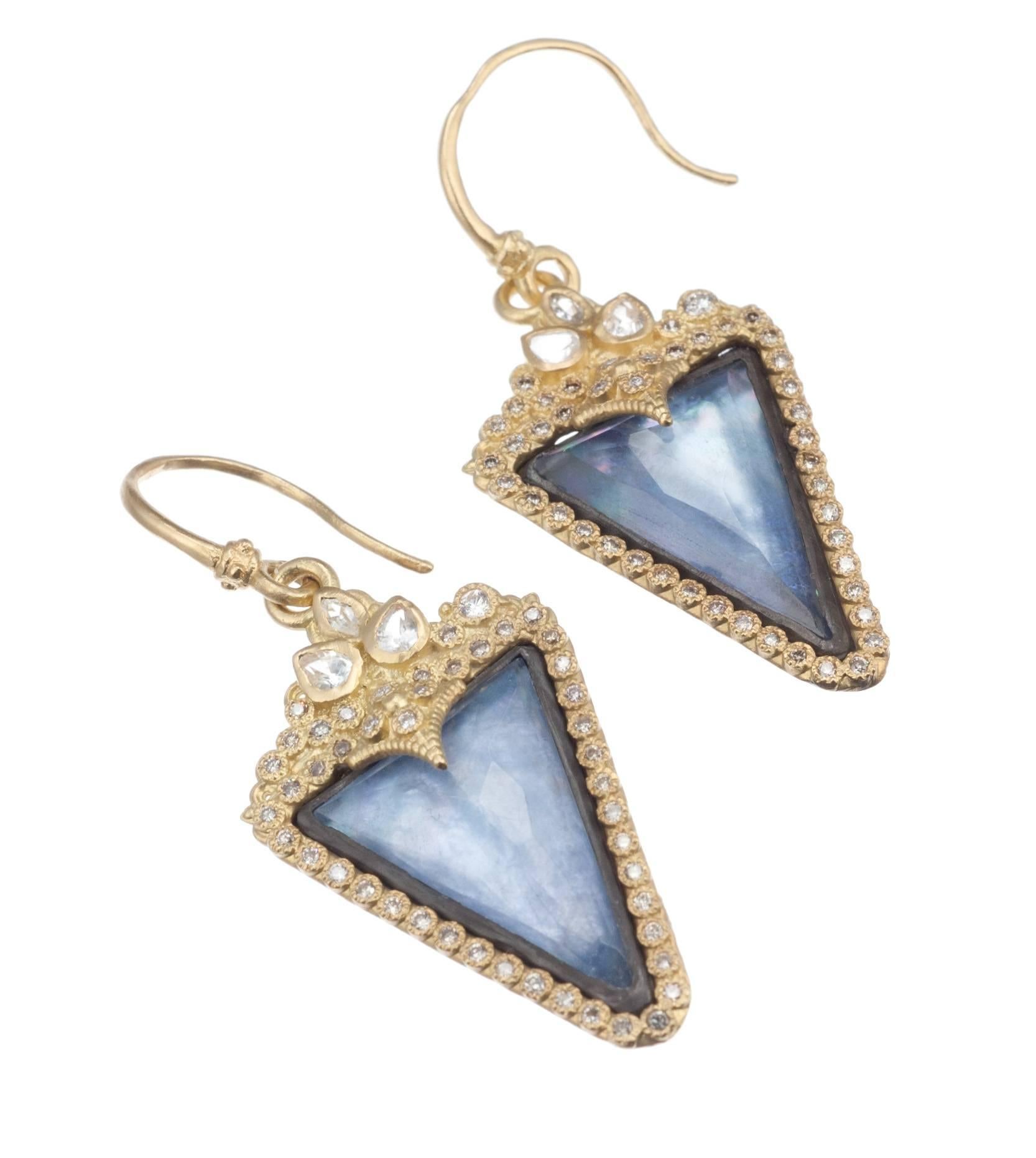 Part of the “Old World” collection from Armenta, a pair of drop earrings set with striking pale blue centerpiece triplets of sliced blue sapphire, a translucent layer of mother-of-pearl and a triangular quartz top. The old world charm continues with