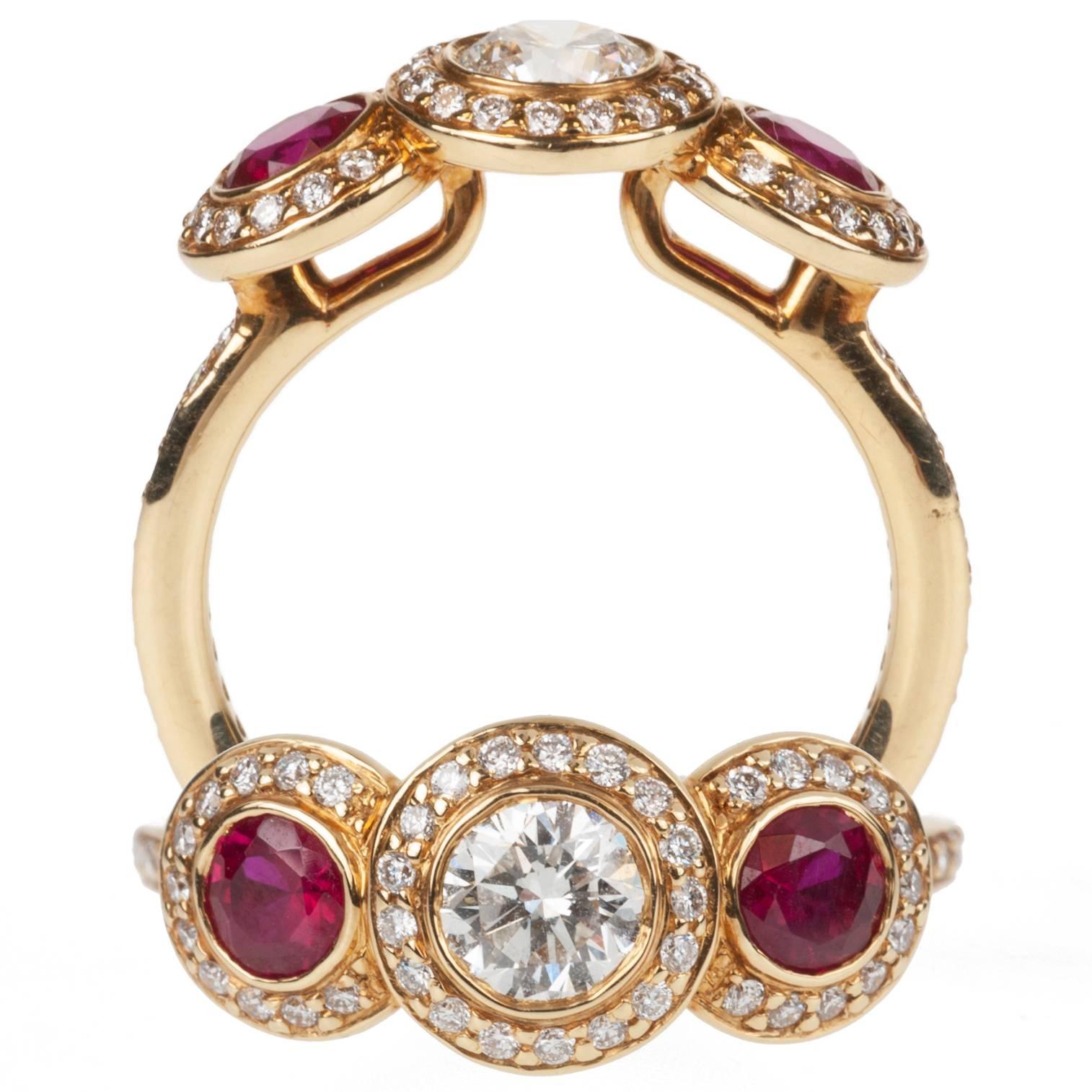 Two round rubies, .64ctw., and a brilliant-cut round diamond, .48ct., are surrounded by pavè-set brilliant-cut round diamonds, .32ctw. in this Ritani ring. The 18-karat yellow gold highlights and emphasizes the gemstones. Size 6.
