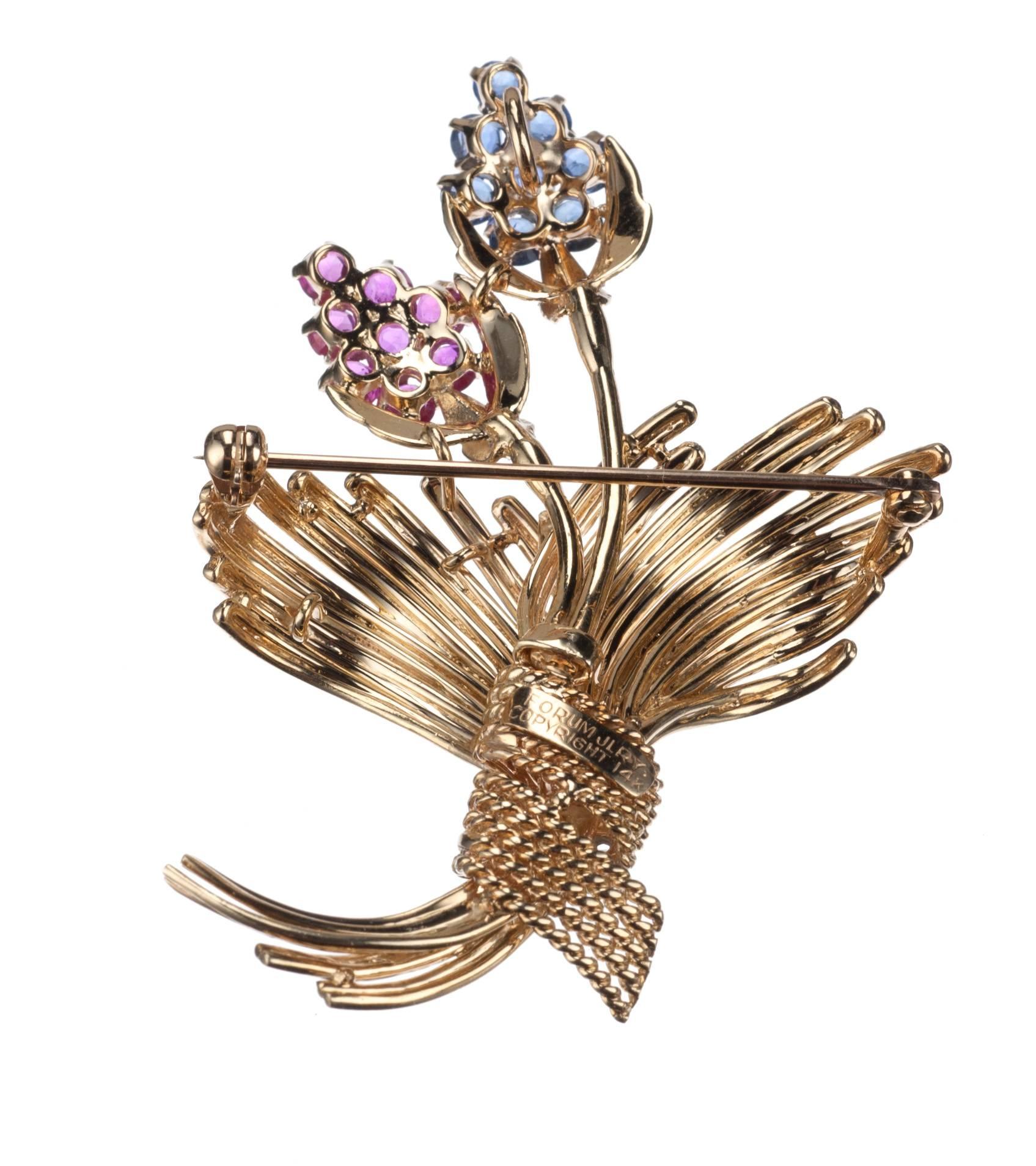 Iconic in its simplicity, a floral bouquet brooch in 14-karat yellow gold. The budding flowers are represented by eight round sapphires, approx. 1.20ctw., and 8 round rubies, approx. 1.20ctw., while the bouquet’s sash is set with three brilliant-cut