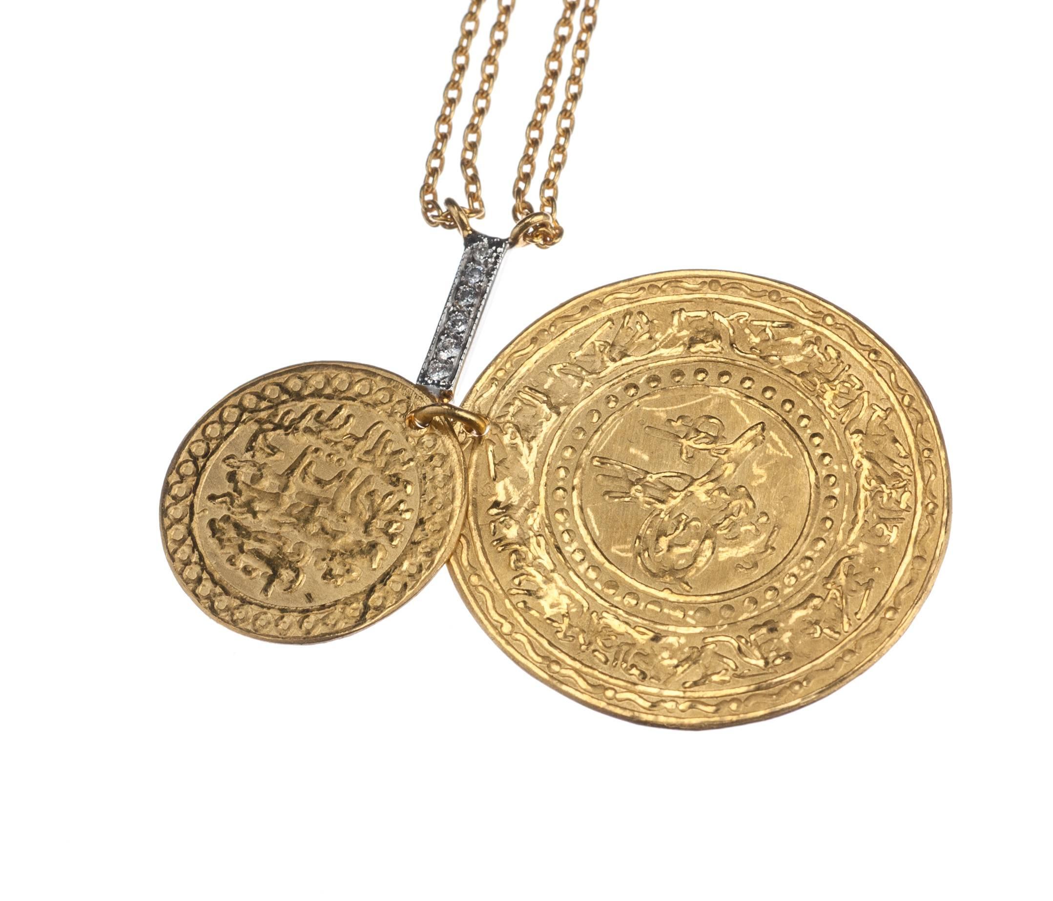 Imbued with the rich warmth of 24-karat yellow gold and the rustic charm of Turkish motifs, a coin necklace from Turkish designer Kurtulan. The two gold coins, one lying against the other, descend from a short length of 18-karat white gold