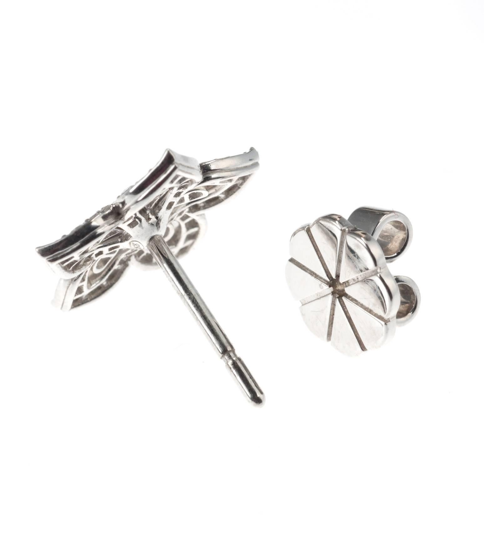Delicate 18-karat white gold flower stud earrings by British designer Lucie Campbell sparkle with feminine allure. Set with 108 brilliant-cut round diamonds, .70ctw. Secured with clutch backs on posts. 