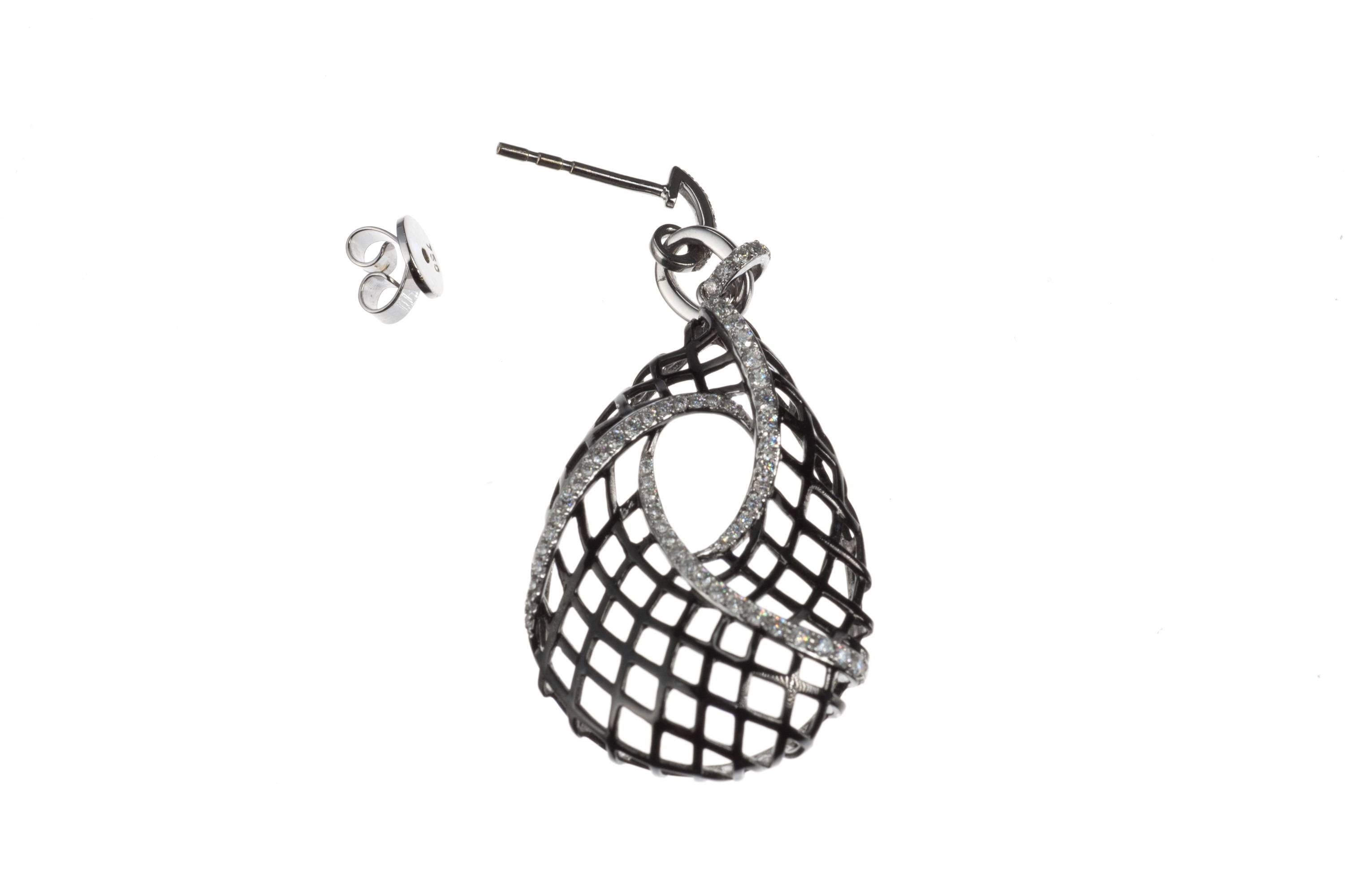 A dramatic pair of pear-shaped drop earrings appears to be woven from black rhodium-plated 18-karat white gold and is accented with ribbons of 154 brilliant-cut round diamonds, .80ctw. of G color and VS2 clarity. Secured with clutch backs on posts.  