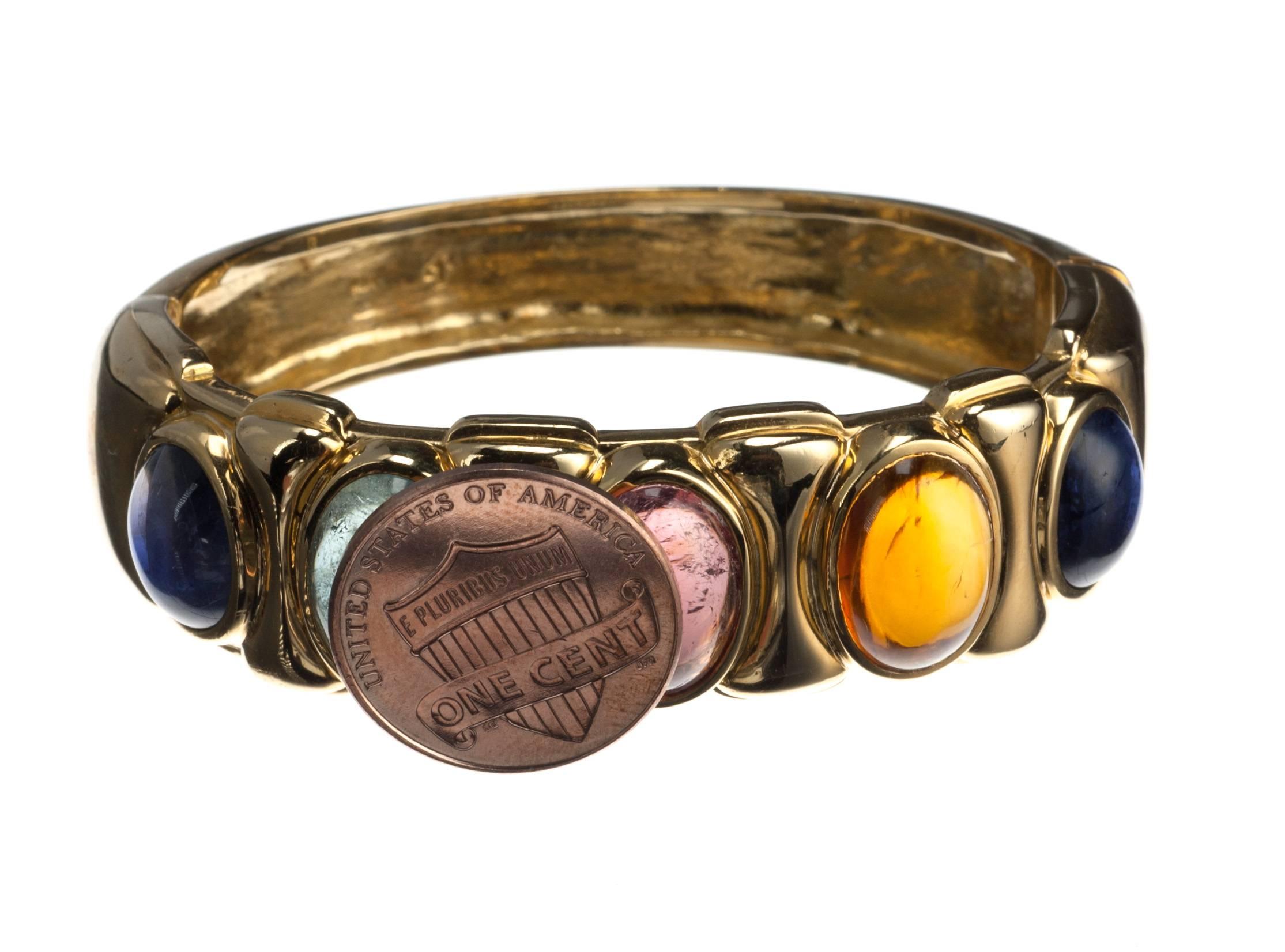 Both classic in its craftsmanship and playful in its use of color, this 18-karat yellow gold bracelet is set with five oval cabochon stones including two iolites, 10x8mm each, one citrine, one pink tourmaline, and one aquamarine, 13x9mm each.