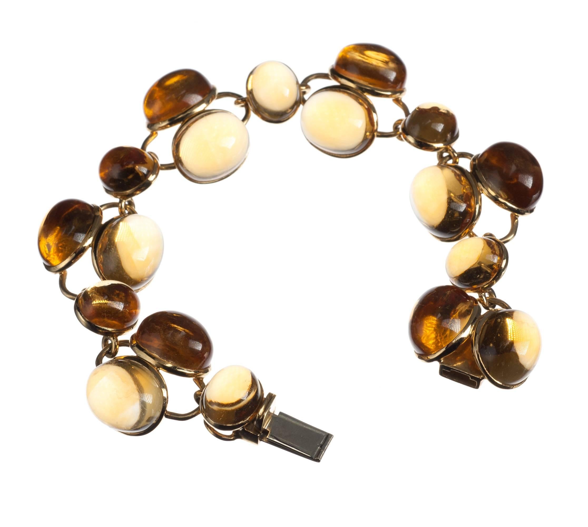 A stunning balance of form and color, this citrine bracelet features 18 oval cabochon citrines, six measuring at 8x12mm and 12 measuring at 10x12mm, bezel-set in a minimalist 18-karat yellow gold framework that complements the curves of the