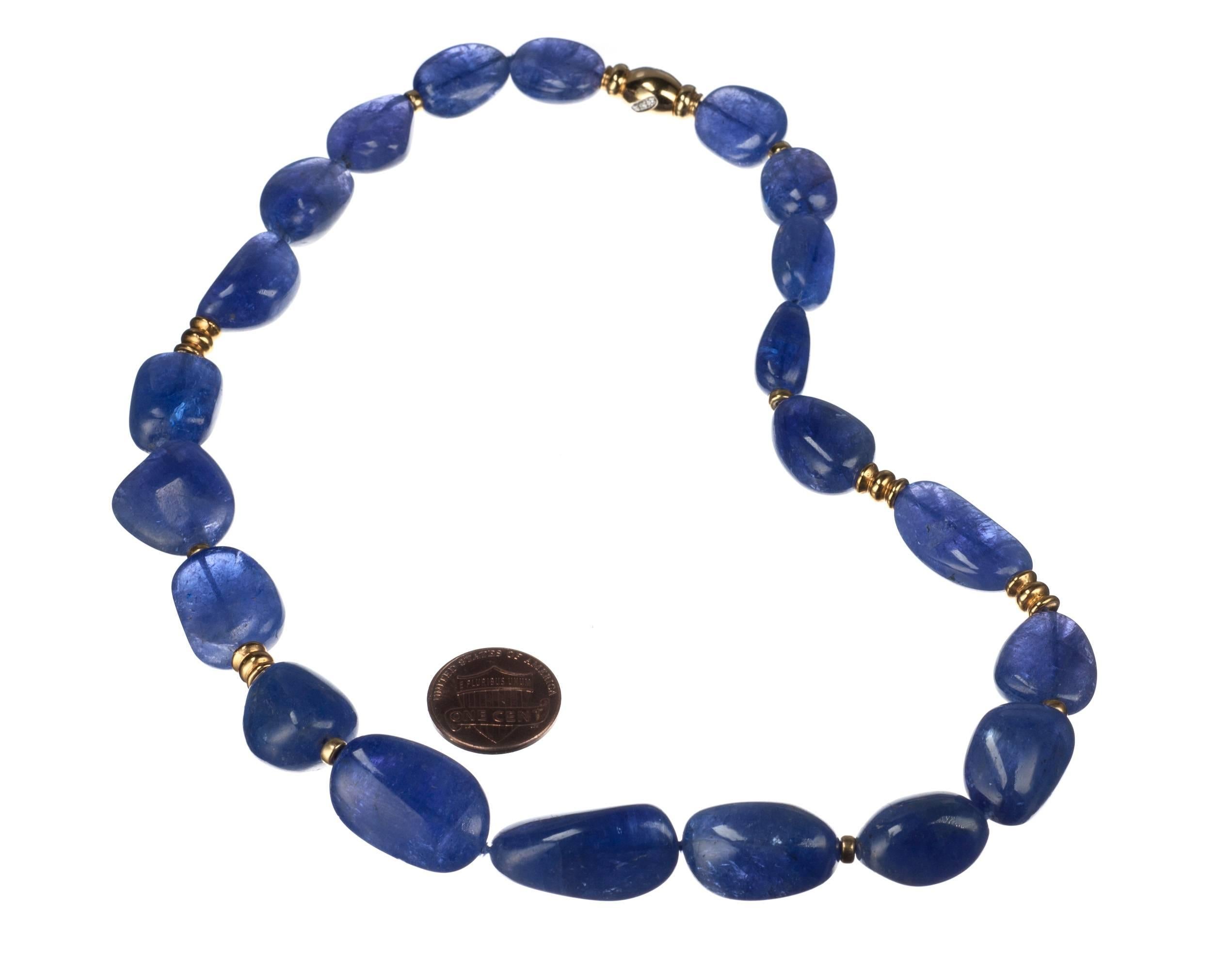 Created by Elleard Heffern Fine Jewelers, a necklace of polished tanzanite nugget beads strung with 18-karat yellow gold beads and rondelles. The 18-karat yellow gold clasp is accented with 9 brilliant-cut round diamonds, .12ctw. of G-H color and VS