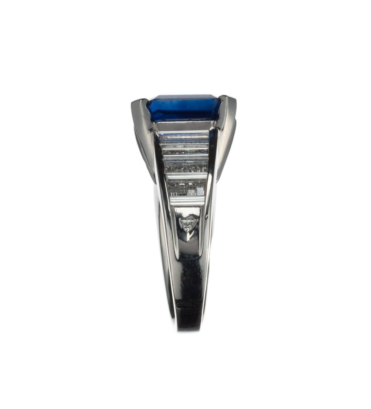 A ring of remarkable stature and poise, this piece features an emerald-cut sapphire, 7.07ct., set in a mounting of platinum and diamond. 44 baguette-shaped and two trillion-shaped diamonds, 1.63ctw. of G-H color and VVS-VS clarity, are set along the