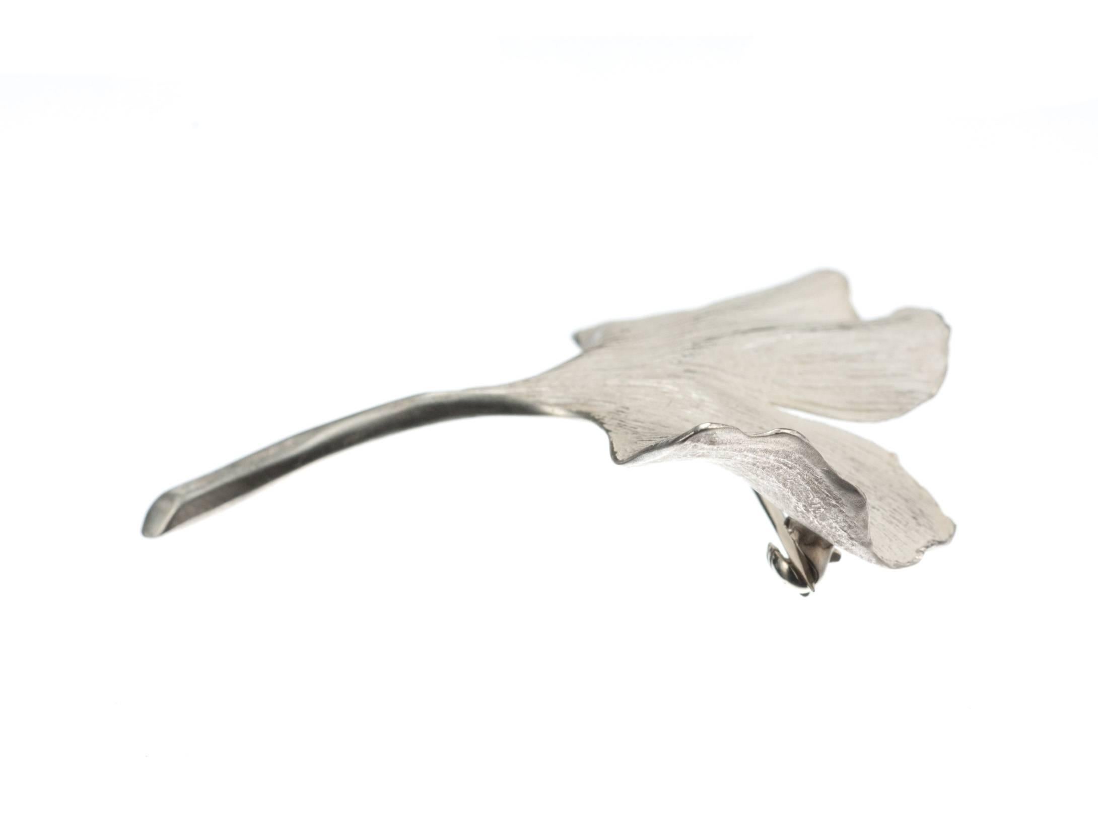 A sterling silver Ginkgo leaf pin, from designer John Iversen, made in his signature naturalistic style and made from actual leaves that are destroyed during the casting process. The soft white matte-finish applied to the pin not only complements