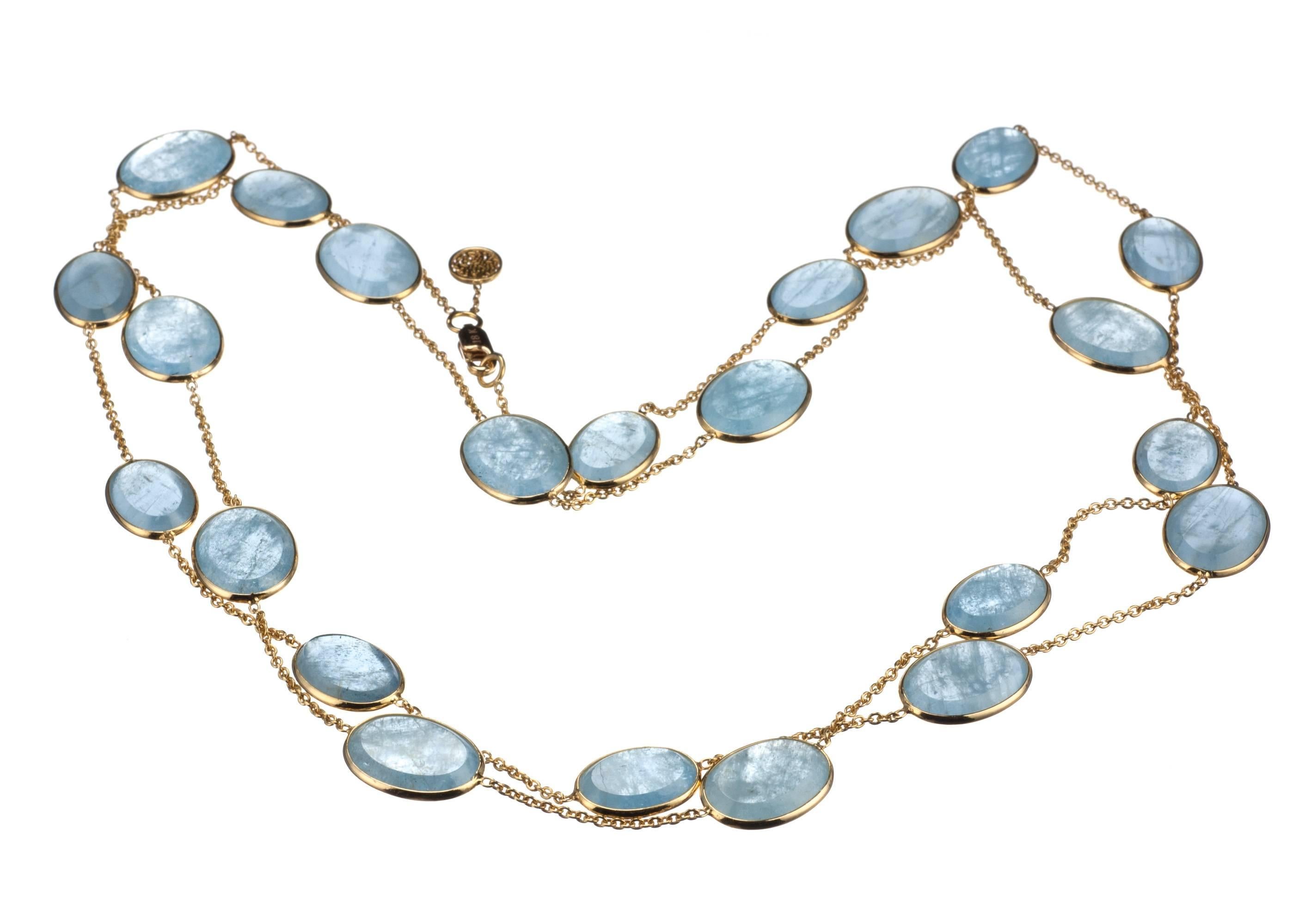 The warmth of 18-karat yellow gold plays with the icy blue of aquamarine in this station necklace. 23 oval slices of aquamarine, 135.38ctw., are bezel set with approx. 1.5” between stations. At approx. 39” in length, this necklace can be worn long