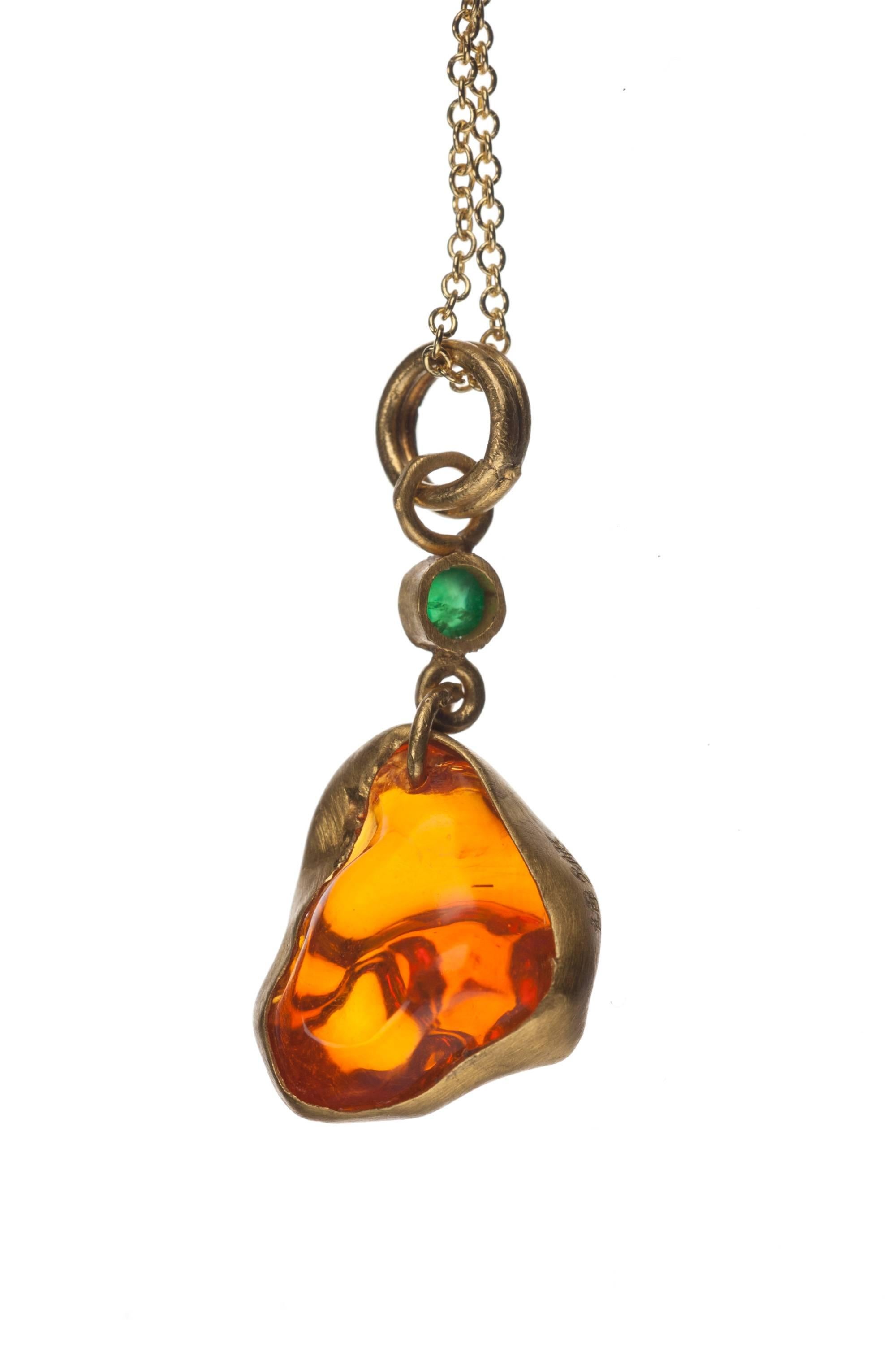 A one-of-a-kind work from designer Lika Behar, this “firedance” pendant makes a bold statement with its intense freeform Mexican fire opal, 4.39ct., set in 24-karat yellow gold and accented with a single round cabochon emerald, .10ct., for a perfect