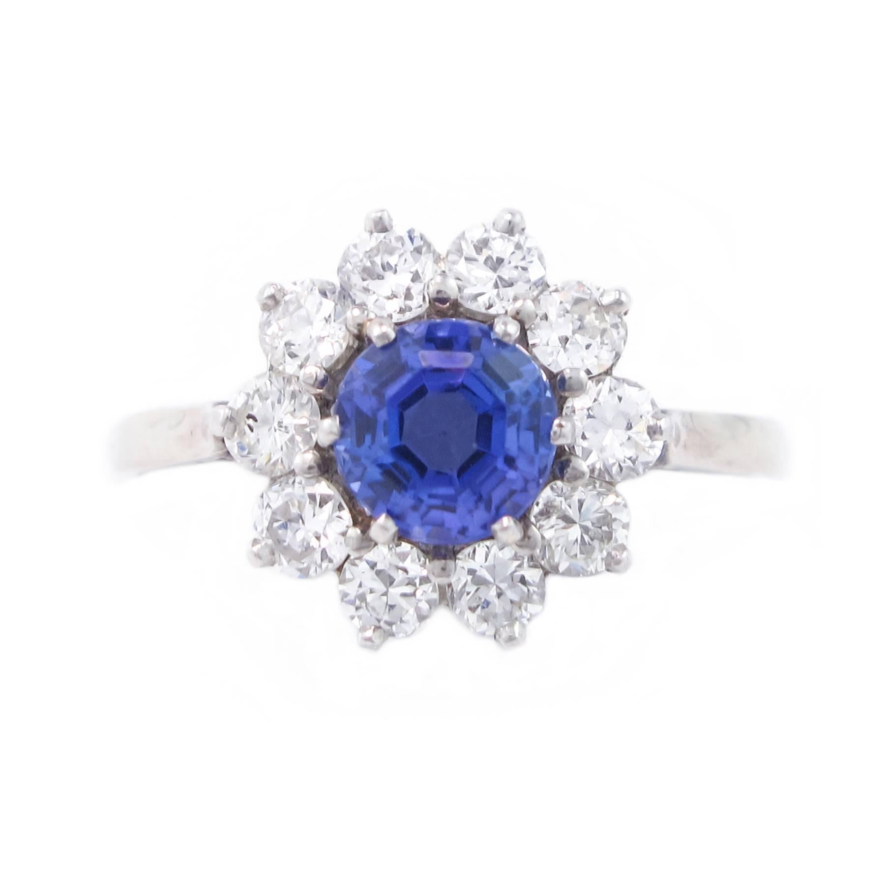 A lovely Tanzanite, Diamond and Platinum Ring.  The 1.50 carat round, faceted Tanzanite is center-set in a surround of clear Diamonds totalling 1 carat in this timeless Platinum ring that resembles a beautiful flower.

The head of the ring is 12mm