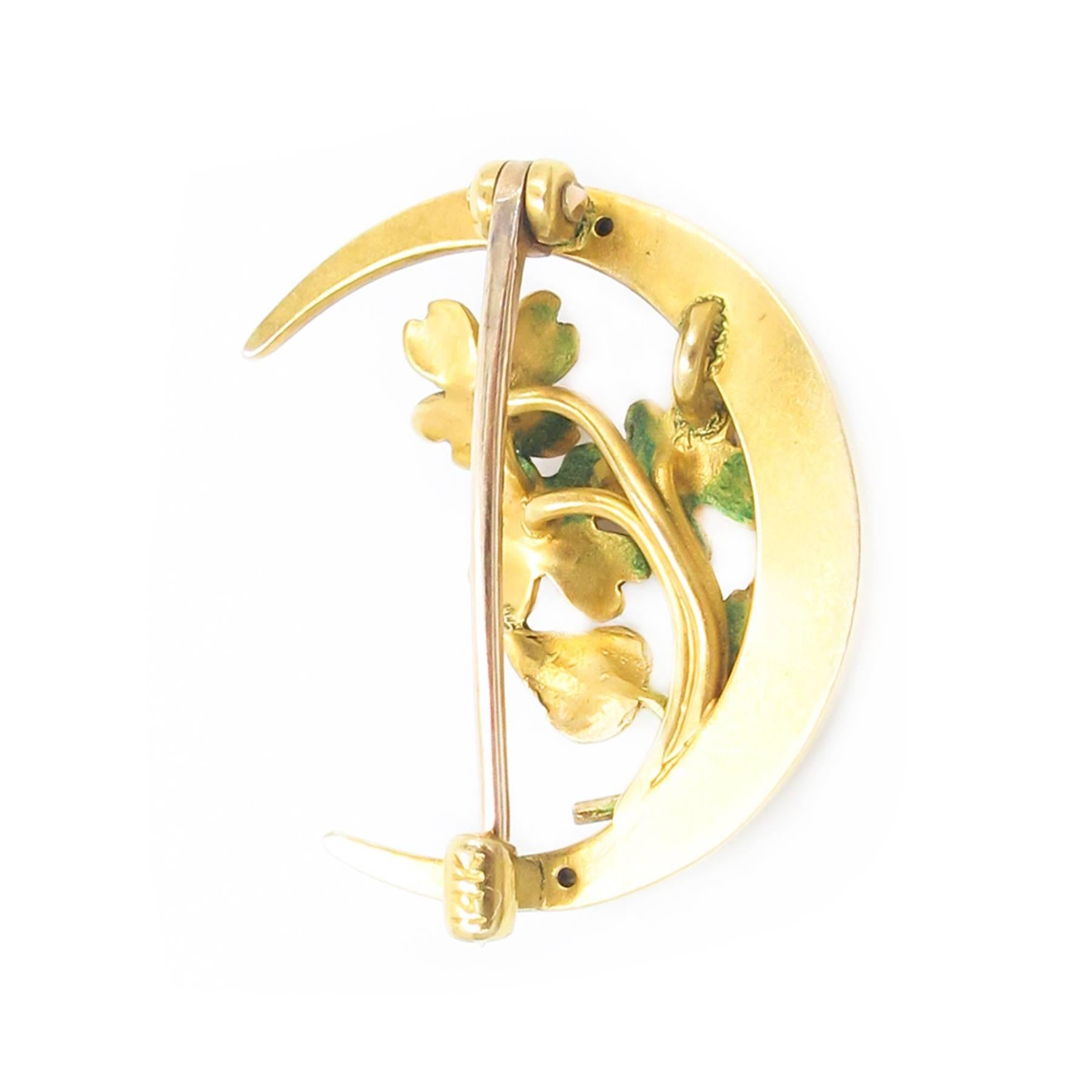 A precious Art Nouveau Crescent Brooch boasts delicate enamel worked flora set with Diamond throats.

Measuring just 1 inch x .75 inch, it is a perfectly sized collar pin with beautiful coloration and wonderful Art Nouveau attention to