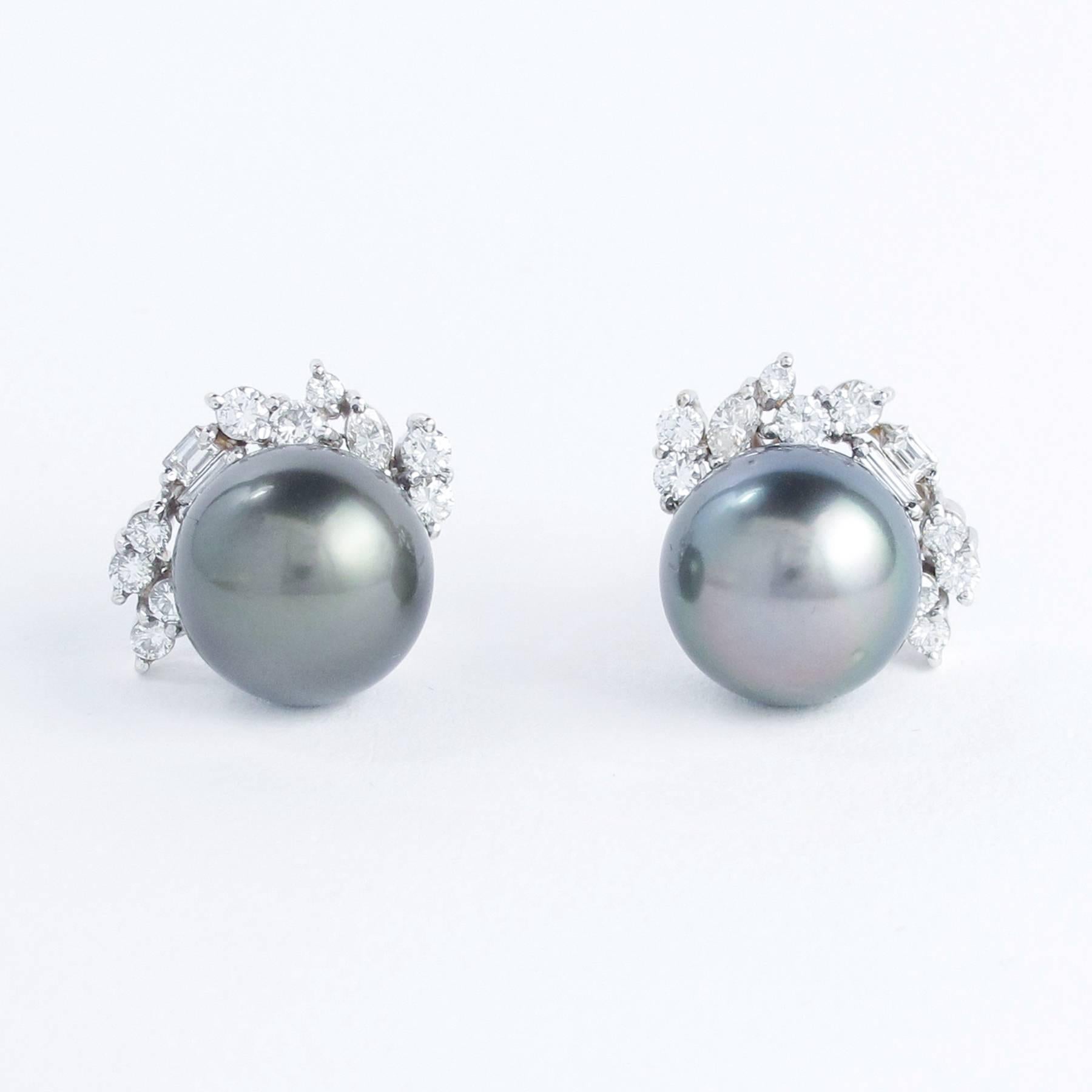 14mm gorgeous  Black Tahitian Pearls are well matched and set with Diamonds  in custom crafted 18K White Gold mounts. The pair are embellished in asymmetrically set with round Brilliant and Fancy Cut Baguette, Marquise, Emerald cut Diamonds with a