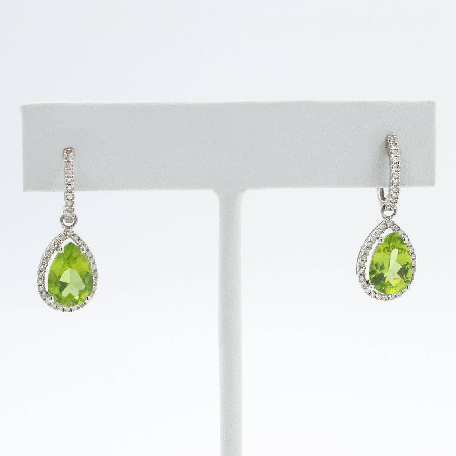 Beautiful pear shaped Peridot drops totaling 4.20 carats are suspended from Diamond set Huggies in 14 karat white gold.

The earrings hang 25mm or 1 inch long top to bottom and are for pierced ears.

CONDITION:  In overall excellent condition with