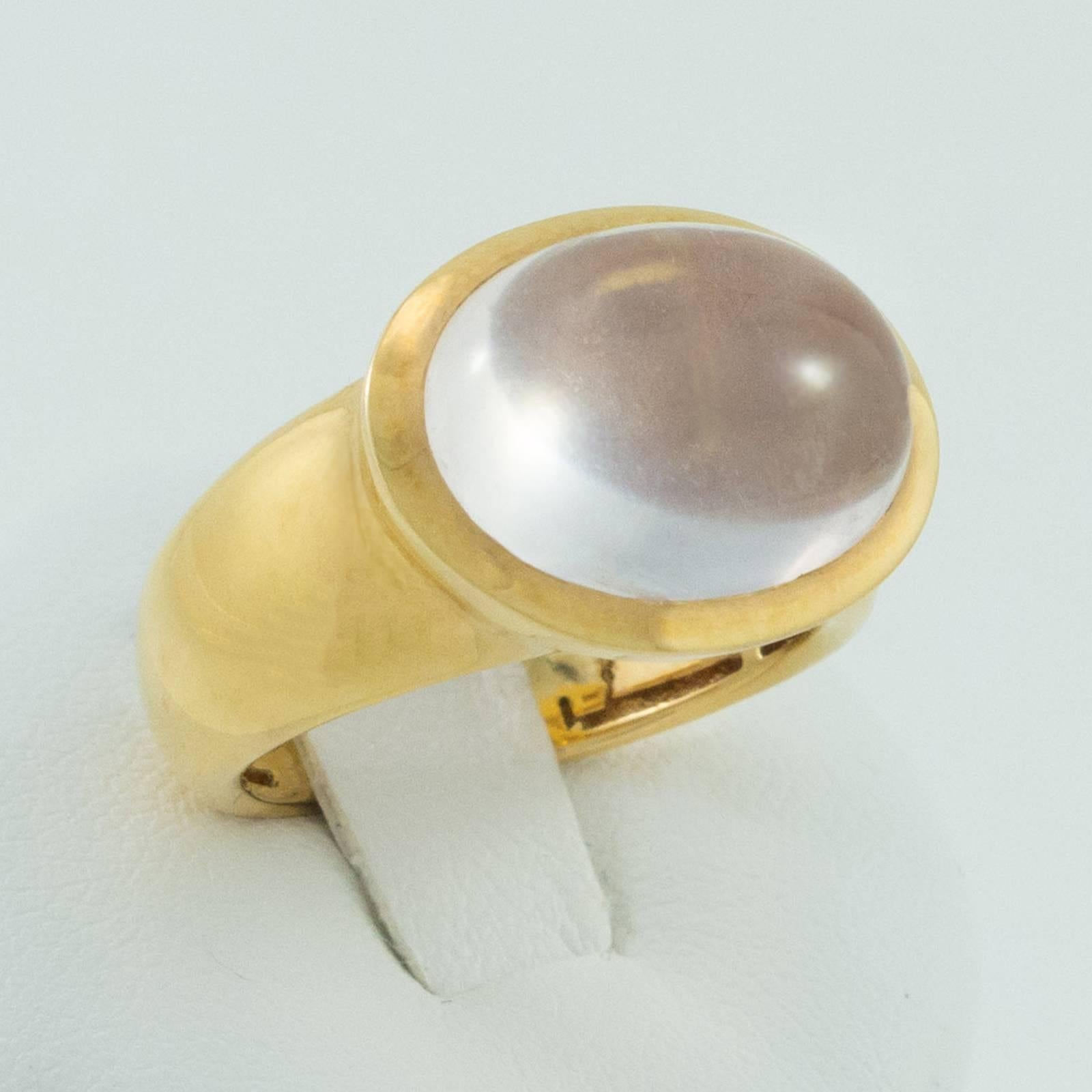 A gorgeous, oval cut cabochon Rock Crystal is bezel set horizontally in a heavy, 18 karat polished yellow gold mount  The top of the gemstone rises a flattering 7mm up off the top of the finger.

Currently a size 7.25, we can custom size this ring